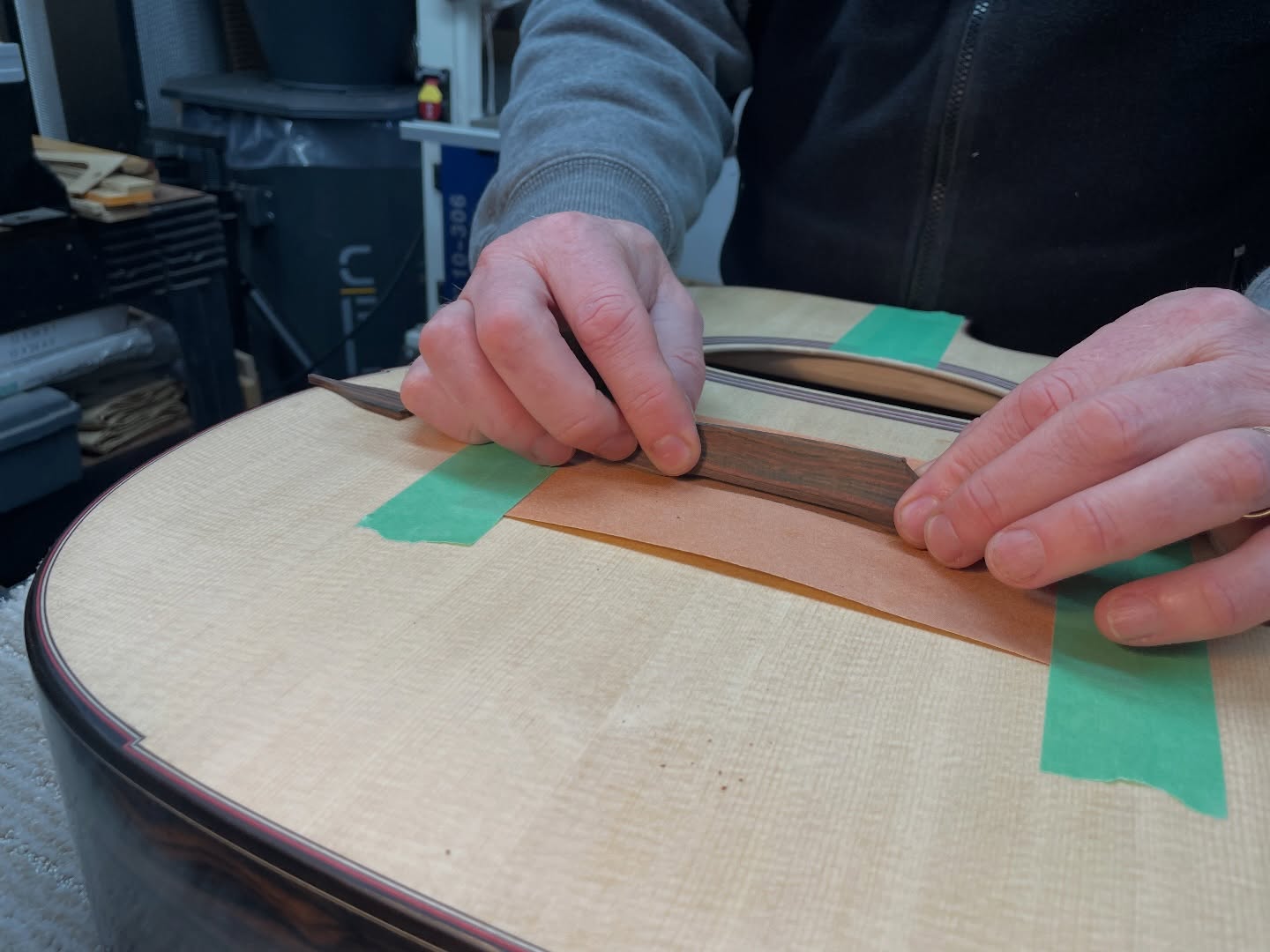 Fitting the floating bridge feet and moustache ends to the top before French polishing the soundboard.