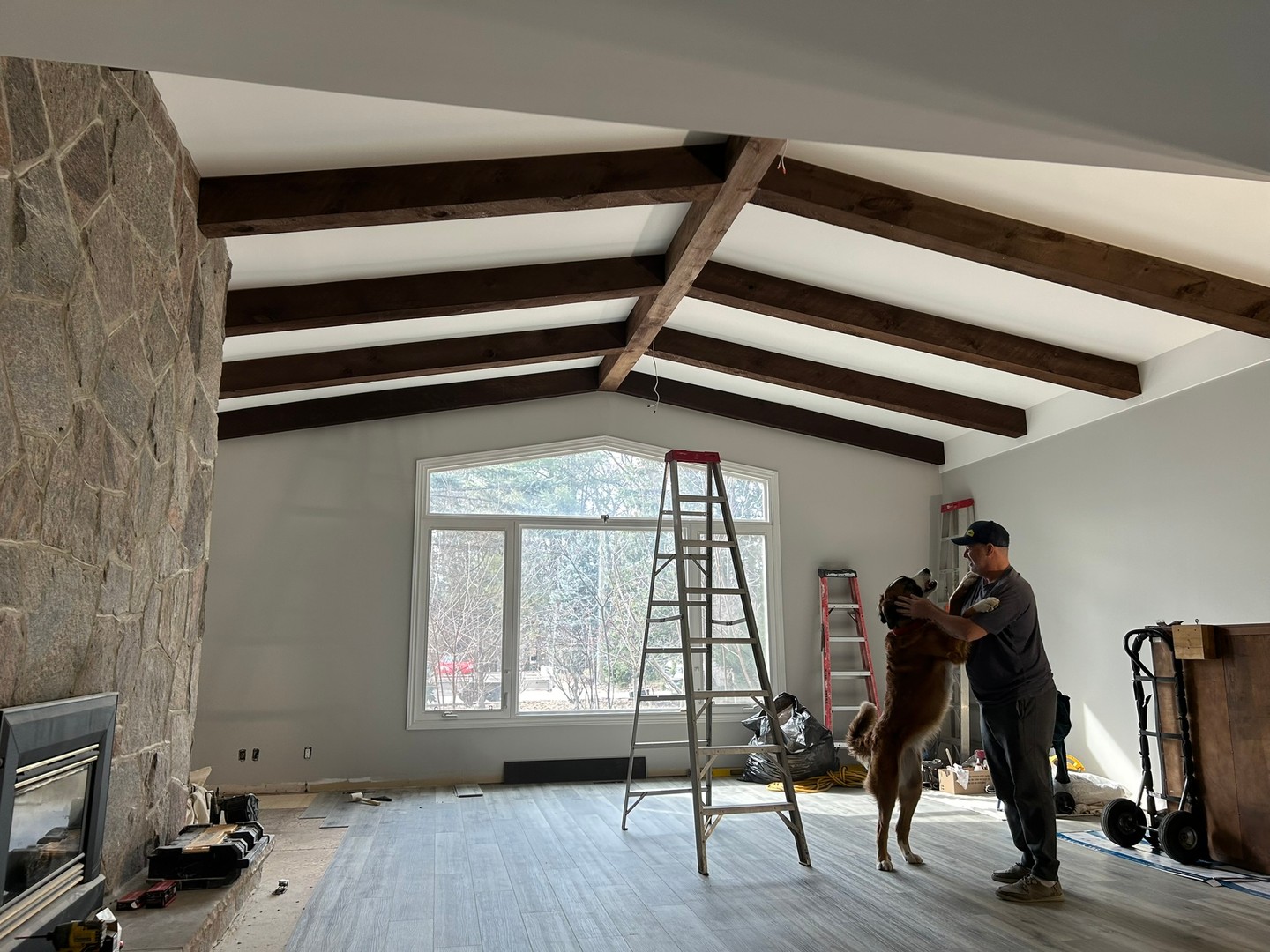 Man’s best friend enjoying the progress right along with us 😂
Wrapping up a beautiful renovation featuring these custom, exposed wood beams and a floor-to-ceiling stone fireplace—plenty of character and warmth for this living room.
It’s shaping up to be a space that really stands out.