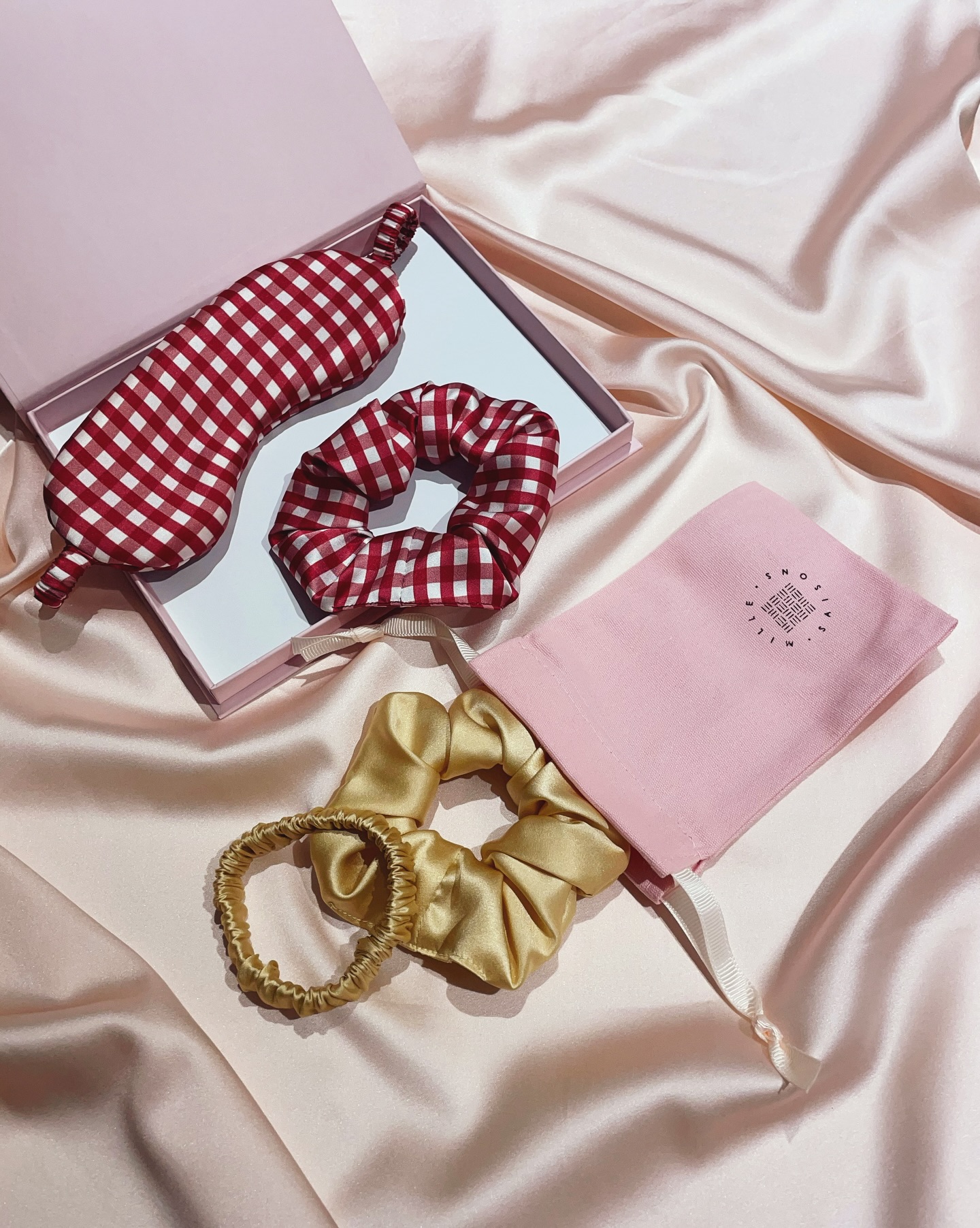 A few gift sets ideas to spark some inspiration for you
From perfect silk sleep sets for your friend who has just had a baby to help them grab some rest whenever they can, to a silk scrunchie set for your sister in law with her favourite colours chosen by you
I am also always happy to put together custom gift sets if you’d like a different selection of products to the sets I have online. Just drop me an email or DM with your dream combination and I’ll let you know the best packaging options and a bundle price!
Image description- 1. An open pink gift box with a red and white gingham print silk eye mask and matching scrunchie with a pink Mille Saisons branded drawstring bag next to it and a gold silk scrunchie and matching silk hair elastic
2. An open pink gift box with three silk scrunchies in golden beige, deep green and red with a pink Mille Saisons branded drawstring bag next to it and three silk hair elastics in mid pink, red and red and white gingham print
3. An open pink gift box with a navy hair bow with a white star and moon print and matching scrunchie with an open white matchbox style gift box next to it with five silk hair elastics in red, mid pink, gold, red and white gingham print and pale pink inside
4. An open pink gift box with three silk scrunchies in mid pink, golden beige and red with an open white matchbox style gift box next to it with five silk hair elastics in red, deep green, gold, bright teal blue and navy blue inside
