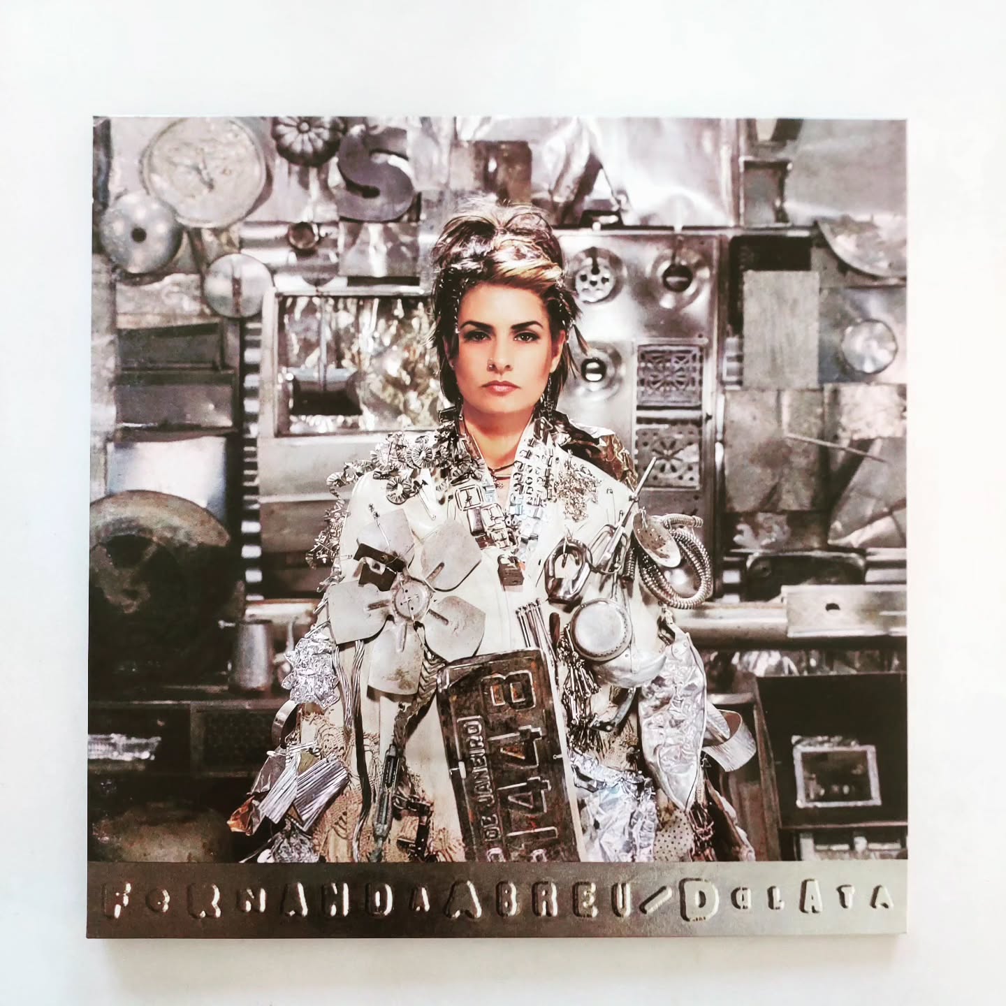 A capa é a prova do crime: 57 quilos de lixo. Sucata. Placa de carro.
Não é figurino, é o peso da cidade que ela vestiu para fazer essa discoteca. É a arte da rua transformada em luxo. Quem tem esse vinil, tem história pra contar e dançar.
Ouve só: 1995. Rio de Janeiro fervendo. Você acha que Fernanda Abreu estava preocupada em tocar na rádio? Não.
Ela fez o que ninguém teve coragem: pegou a batida crua da quebrada , o cheiro do asfalto, o funk Carioca que a sociedade tentou marginalizar, e transformou no "SOM".
(A gíria? Veio do "Verão da Lata", quando a tripulação de um navio teve que dispensar latas e mais latas de maconha no mar. "Da Lata" virou sinônimo de qualidade e transgressão .)
Da Lata não é música Pop. É crônica , manifesto , é moderno e pista de dança ao mesmo tempo.
Quando ela canta "Veneno da Lata" e "Garota Sangue Bom" , ela está te dando o roteiro de uma cidade que é luxo e lixo, tudo misturado na mesma batida. O Rio de 1995 está aqui .
A Fernanda Abreu soube traduzir os anos 90 como ninguém. E sim, é um som atemporal que gera uma eletricidade quando a gente bota pra girar na vitrola.
#FernandaAbreu #DaLata #VinilRaro #MúsicaUrbana #AvozDoVinil