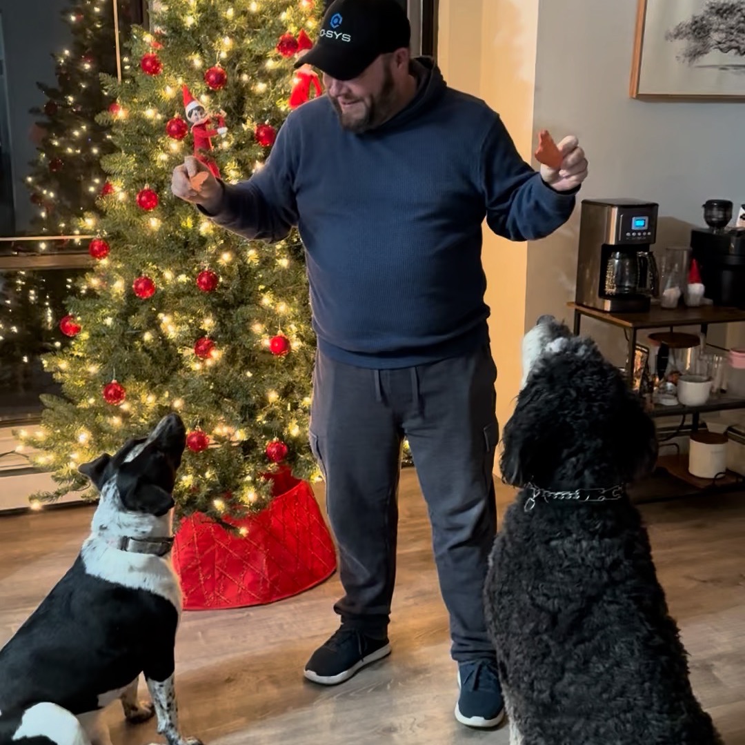 Two happy pups getting their TAJ Pet Sweet Potato Treats from their Dad.