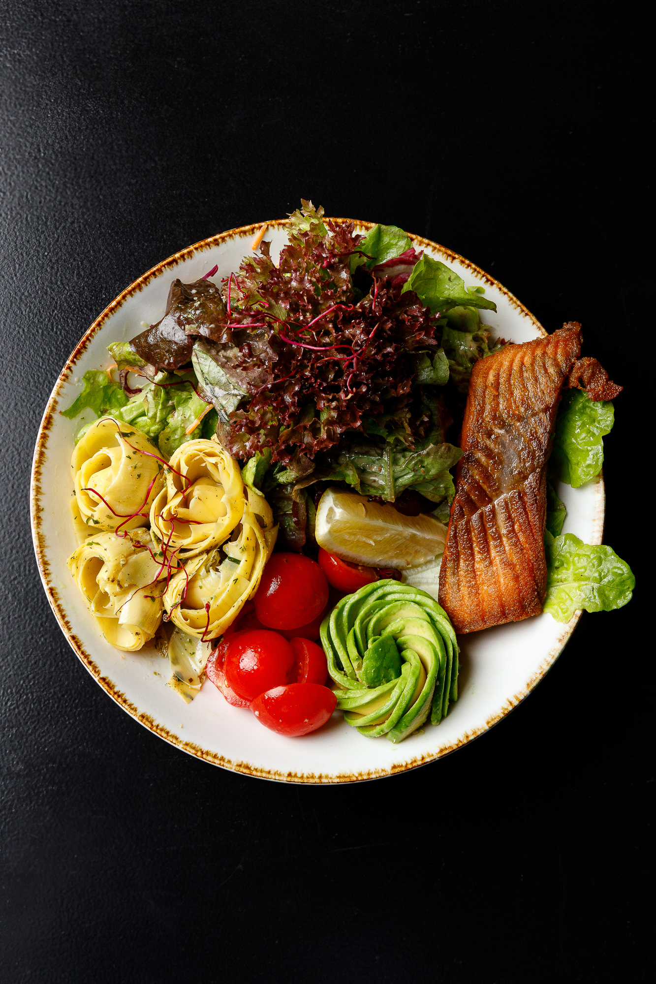 Frisch, farbenfroh und einfach gut: unsere Avo Salmon Bowl vereint das Beste aus beidem – Genuss und Leichtigkeit. Zart gebratener Lachs, cremige Avocado, eingelegte Artischocken, knackiger Salat und frische Zitrone – alles, was ein Gericht braucht, um sich nach Sonne und Wohlgefühl anzuf