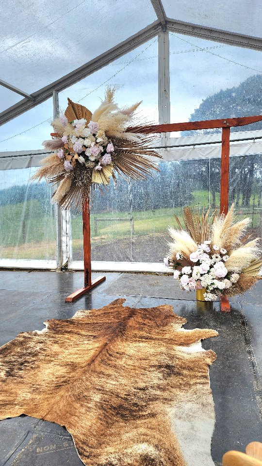 A rustic-chic western wedding with the sweetest atmosphere. Even after wild weather pushed the ceremony inside the marquee, it turned into the most beautiful, intimate space — soft blush tones, dried textures and a hint of cowboy charm for the guests. Loved bringing this look together for the couple.
#Decodays #WeddingFlorist #RusticWedding #WesternWedding #BarnWeddingStyle #MarqueeWedding #MelbourneWeddings #CountryWedding #DriedFlowers #FauxFlorals #ArtificialFlowers #WeddingCeremonyDecor #WeddingInspo #BrideToBe #EngagedCouple #PakenhamFlorist #GippslandWeddings #YarraValleyWeddings #MelbourneBride #EventStyling #WeddingAisleDecor #BohoWeddingStyle