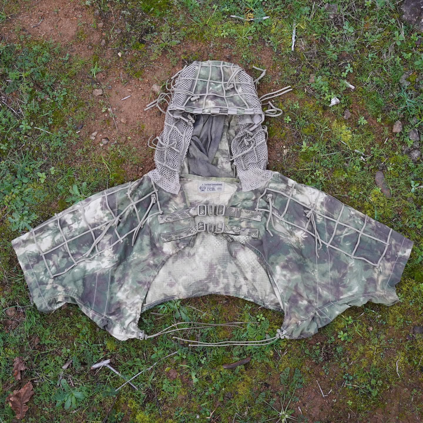 Enhanced Legacy Surgeon
Designed as an intermediate/mid back coverage Vis/nIR spectrum concealment item, the Enhanced Legacy Surgeon has nylon Para-Grid lattice and Vegetation-Tie-Cords w/Cord Locks bar-stitched all throughout the entire outer shell of the garment. These support the attachment and holding of jute and natural foliage in place to achieve maximum results, allowing the end-user to blend seamlessly into the natural surroundings.
Additionally the Surgeon features a Hood-integrated Veil that can be draped over the End-user's weapon or observation system, enabling optimal lowering of the firing position's overall visual spectrum signature. The rifle veil can be rapidly removed in an emergency situation via an integrated QD "Rip Cord" veil-to-hood attachment design.
+ 57/43 NyCo Extreme IHWCU textile construction produced by Brookwood Rolled Goods exclusively for Sniper Dynamics.
+ Adjustable one-size-fits-most via torso & hood tension adjustment Cords for a custom fit.
+ Quiet G-Hook Chest Closure with included Fastex Buckles to allow for end user preference.
+ Designed to be worn in unison with all chest rig plate carriers, waist-mounted gear, and backpacks.
@tacticalconcealment @mmitextiles @brookwoodcompanies @murdockwebbingcompany