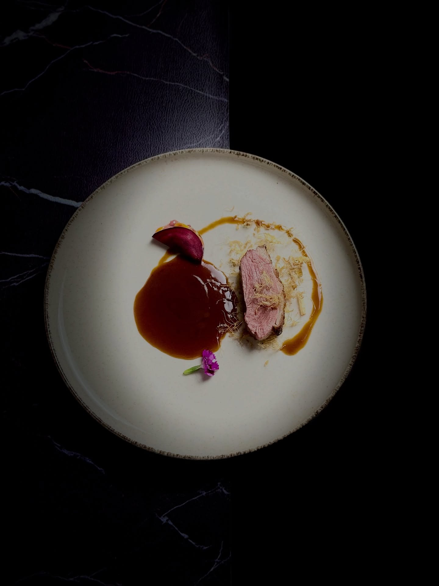 【Le Feu du Gingembre sous la Lune | 寒月姜火】
🍂🦆 Ce plat s’inspire de la préparation traditionnelle du canard au gingembre (Jiāng Mǔ Yā), revisitée ici avec un magret de canard, une sauce au gingembre et de fins filaments de gingembre frais. Puissant mais maîtrisé, il incarne l’esprit de la cuisine hivernale chinoise.
❄️🔥 Grande Neige (Dà Xué) : le monde se replie sur lui-même; la chaleur profonde du gingembre agit comme un feu intérieur;
🌗 Solstice d’hiver (Dōng Zhì) : naissance du yang ; la chair du canard, naturellement plus fraîche, trouve l’équilibre grâce au gingembre;
🥶🫚 Petit Froid (Xiǎo Hán) : le froid s’intensifie, les filaments de gingembre stimulent et réchauffent directement l’organisme.
🍲 Le Jiang Mu Ya est un plat emblématique du sud-est de la Chine et de Taiwan,
traditionnellement consommé en hiver. Ses principes fondamentaux : une grande quantité de gingembre mûr, longuement travaillé dans l’huile de sésame ; du canard cuit lentement avec le gingembre ; parfois l’ajout de plantes médicinales selon les écoles culinaires.
🌿 D’un point de vue diététique : le canard nourrit sans excès de chaleur ; le gingembre réchauffe, active la circulation et combat le froid ; l’ensemble vise un équilibre thermique, essentiel pendant l’hiver.
✨ Cette version met en valeur le magret pour une lecture plus légère, contemporaine et gastronomique du grand classique hivernal.
🦆🔥 这道菜取传统姜母鸭之法,但以鸭胸这一更为克制与细腻的部位呈现,搭配姜母鸭酱汁与细切姜丝。浓而不滞、热而不燥,是一道典型的“冬令温补之味”。
❄️ 大雪:天地封藏,人体阳气内敛。酱汁中姜与药材的深沉辛香,如暗火潜行,为身体积蓄热能;
🌗 冬至:阴极而阳生。鸭肉性偏凉,却在姜的引导下转为平衡,寓意“以热制寒,以柔养阳”;
🥶🫚 小寒:寒意渐紧,姜丝直指肺胃,温中散寒,使身体不惧冷冽。
🍲 姜母鸭起源于中国福建与台湾一带,是极具代表性的冬季滋补菜式。其核心不是“鸭”,而是“姜”。传统做法强调:
🔥 大量老姜,以麻油慢火煸炼;
🍖 鸭肉与姜同煲,长时间炖煮;
🌿 常辅以少量中药材(如当归、熟地、黄芪等,因流派而异)。
🌗 其饮食逻辑在于:鸭肉滋阴、不燥;老姜大辛大热、行气散寒;二者相合,形成“寒热相济”的结构,特别适合冬季体虚、手足易冷者。
✨ 本菜以鸭胸呈现,降低油脂与厚重感,使姜母鸭从“民间滋补炖品”转化为更当代的精致表达。
🗓️ Reservation: www.bistrowu.com
#aix #aixenprovence #aixenpce #aixmaville #aixenprovence❤️
