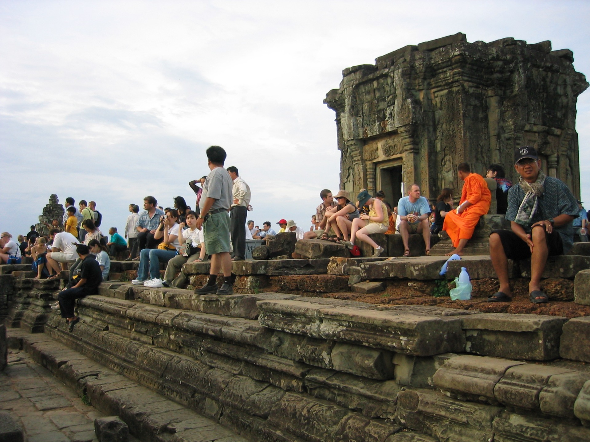 Passage from Travels in the Land of Hunger: A backpacker's earthbound journey from the East to the West 🌏📖
Tuesday, May 20, 2004
Leonardo and the other driver took us to Prasat Trapeang Ropou. Many tourists and backpackers gathered at this site to hike and climb Phnom Bakheng, a Hindu and Buddhist temple built in the 9th century, to view the sunset from its peak. We followed the crowd to a ruined stone staircase to ascend a hill covered in thick tropical vegetation. At the top of the stairs and across a flat open plain stood the impressive walled pyramid temple ruin of Phnom Bakheng, composed of five levels. We walked across the plain peppered with stone ruins to the nearly vertical sandstone staircase that led up the eastern side of the temple. Once we had climbed the stairs, Robert and I took in the beauty of the thick, green canopy of tropical trees that expanded to the grey horizon in all directions. Hidden within this verdure were the monuments of Angkor’s long and once-lost civilization.
We waited for the sun to set, knowing the cloudy evening would prevent the best experience. Regardless, waiting at the top of this temple, crowned by five towers with so many people from around the world, was fascinating.
#TravelsInTheLandOfHunger #travelmemoir #memoirwriting #indieauthor #bookexcerpt #backpacking #backpackinglife #solotravelers #travelphotography #cambodia #cambodiatravel #adventuretravel #traveldiaries #siemreap #phnombakheng