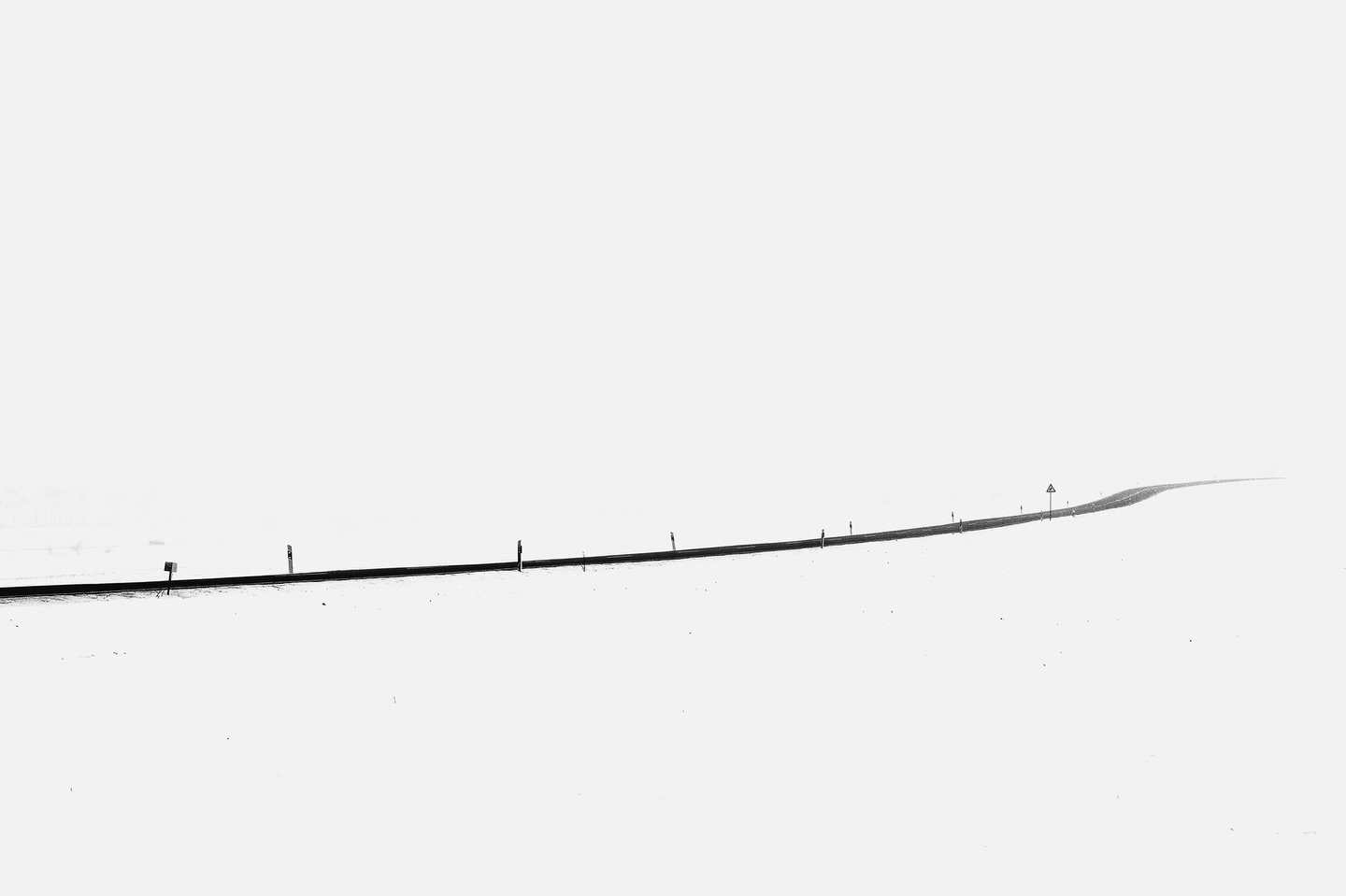 Into the white.
During winter we often had almost white-out conditions and even if it’s dangerous to drive, I’m a big sucker for that kind weather. I love visiting the spots I scouted earlier in the year to check if they really work in winter. It’s a lot of trail and error or just being out in the cold but occasionally everything comes together and the monochrome minimalism pops up in front of your eyes.