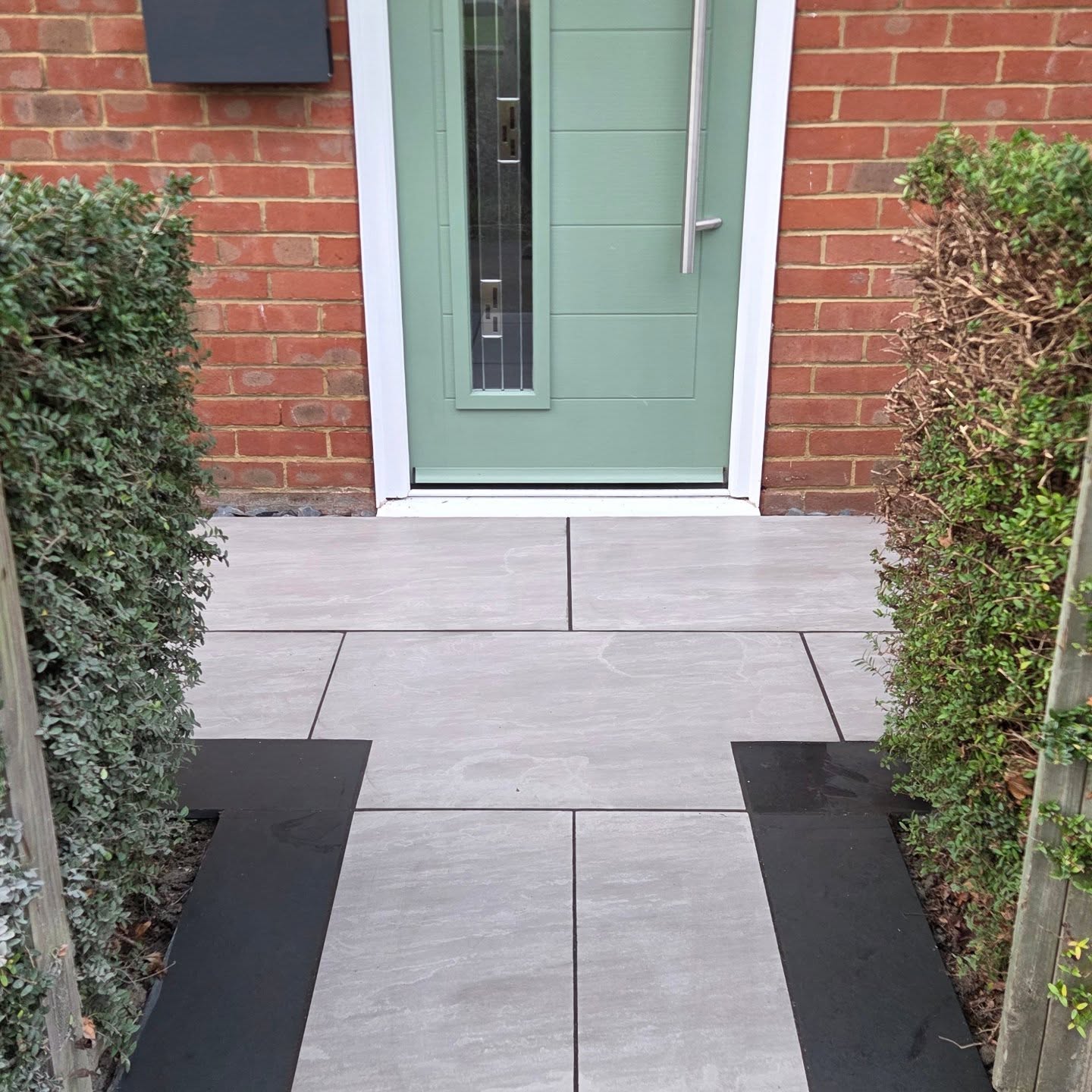 Front path renovation for a returning customer in the village. Replacing a tired concrete path, new smart porcelain tiles with slate edge brings this frontage upto date. New planting with matching edging to boot. Get in touch for a free quotation today. ð