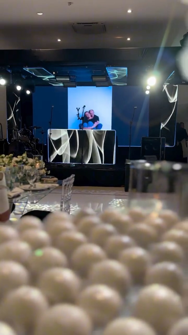 ✨ Casamento Luana & Willian
📍 Ponta Lagoa Garden
Um projeto pensado para criar unidade visual, sofisticação e emoção em cada detalhe.
O painel de LED principal, complementado por tiras de LED suspensas sobre o palco e a bancada do DJ, compôs um cenário moderno e envolvente, com a iluminação totalmente harmonizada aos painéis, garantindo fluidez estética e impacto visual do início ao fim.
A pontuação cênica foi aplicada com precisão para valorizar o espaço, enquanto a iluminação nas mesas dos convidados trouxe elegância, conforto e destaque aos momentos à mesa.
O sistema de som, dimensionado para atender com excelência a energia da banda @ursoscaipiras, entregou clareza e emoção do início ao fim da festa.
⭐️ Ariel Som e Luzes - Experiências visuais e sonoras à altura do seu evento.
Decoração e Cerimônial: @emartizee
Foto e Vídeo: @javorski_producoes
Banda: @ursoscaipiras
Pista: @vinilcenter