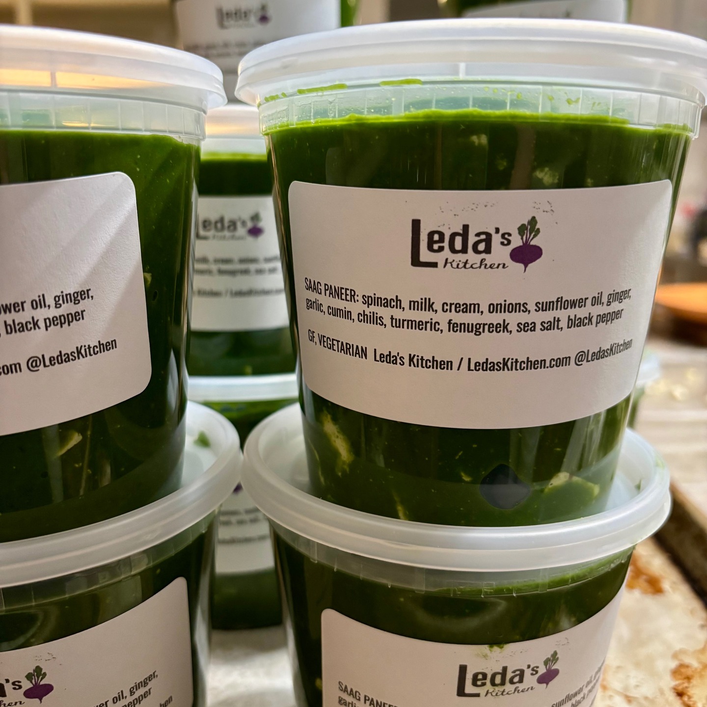 On the New Year’s Day pickup menu, my top seller: saag paneer. My saag goes above and beyond, featuring small-batch, house-made paneer, organic spinach, plenty of onions, ginger, and garlic, all finished with a touch of cream to enhance the soft, earthy flavors. Come see what the excitement is all about! To order, just follow these three simple steps:
1. Place your order at http://ledaskitchen.com by Tuesday at 7PM.
2. Look for your confirmation email with the pickup address.
3. Collect your meals on Thursday between 4 PM to 7 PM or by special arrangement.
About: At Leda's Kitchen, I draw on my adventures as a private chef, cookbook author, and co-owner of Dosa Kitchen Food Truck to offer weekly-ish heat-and-eat meals designed to awaken your senses and fit seamlessly into your schedule. My menus feature curries, stews, nourishing soups and stews inspired by diverse food traditions. I cook with high-quality ingredients including free-range meats and focus on local and organic sourcing. You decide when to eat, as all dishes are designed to reheat beautifully, maintaining or even increasing their original deliciousness.