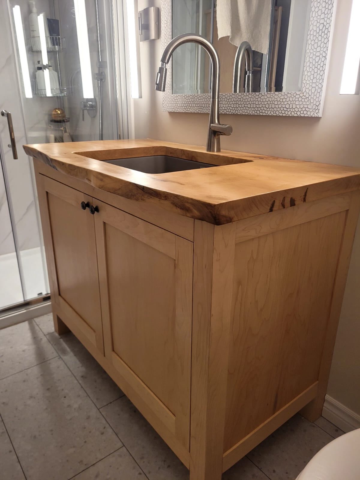 Custom vanity, linen closet, and counter top built by Maximus Craftsmanship for a customer’s washroom. These cabinets are entirely built of maple, using joinery techniques, no nails or screws. The maple slab was harvested just outside of London. Contact us today for your own local custom cabinetry.