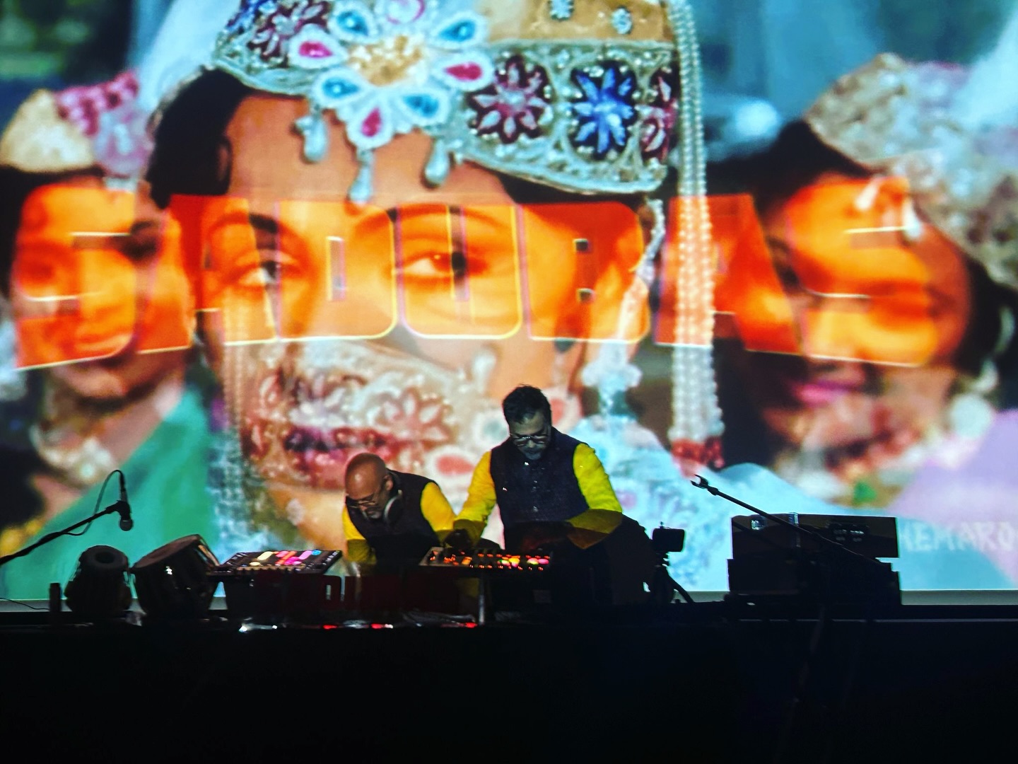 In the 1960 epic #bollywood epic Mughal-e-Azam, Anarkali and Bahar are set against each other in court, using voice, poetry, and presence to win favor before Prince Salim. On screen, it’s a devotional performance. In reality, it’s a full-on musical showdown.
Bahar sings to impress the court—controlled, confident, clearly playing the game.
Anarkali sings from somewhere deeper. Less polished, more felt. And Salim instantly locks in.
Everyone else hears music.
Salim hears the truth.
This scene is a huge reference point for Sadubas—and something we were actively channeling during our performance at the @bowersmuseum 🌹 Ritual meets competition. Devotion turns into desire. Repetition builds trance. The court becomes a kind of ancient disco dancefloor: symmetry, hierarchy, sensuality, refined beauty—and one voice shifting the entire room. Thank you @modernmedisin for the capture ❤️