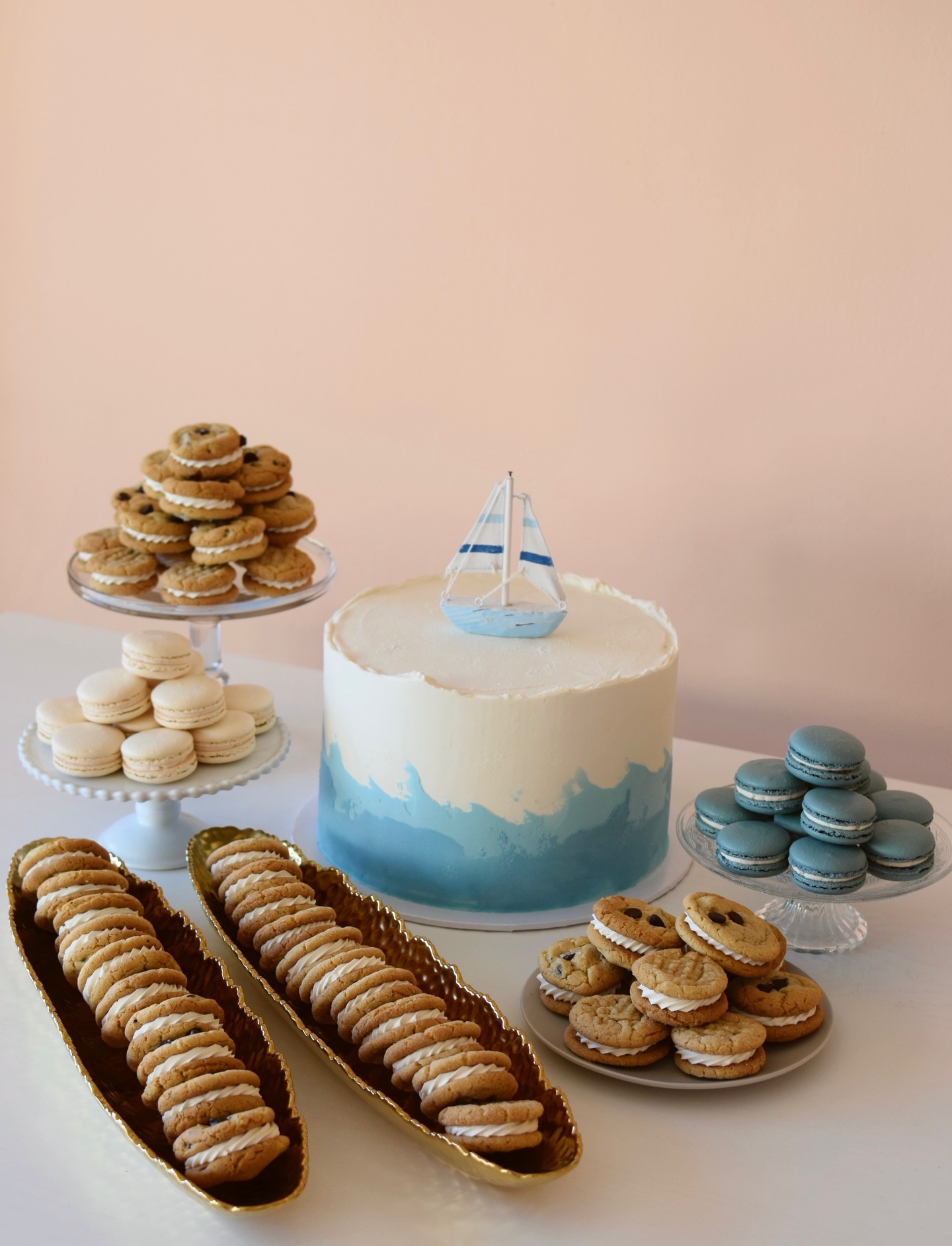 Sailing into a sweet new year with a beautiful dessert table for a winter baby shower 🩵 Chocolate Fudge Cake, Mini Peanut Butter Cookie Sandwiches, Salted Caramel Macarons & Mini Brown Butter Chocolate Chip Cookie Sandwiches 🌊 All desserts are custom designed to coordinate with your theme- head to our website to get the ordering process started!