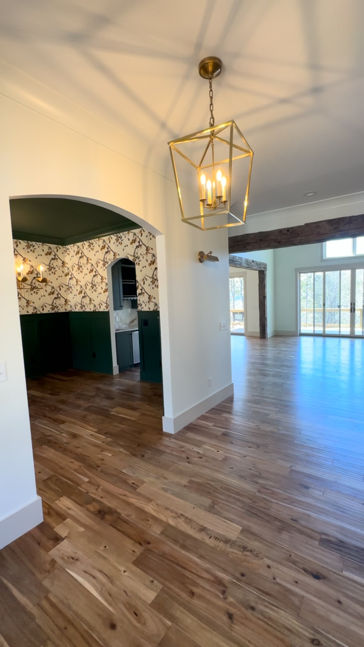 Stepping into a foyer that opens up to a statement dining room ✨ wallpaper moments, real exposed beams, and a living space that instantly feels like home. So cozy. #jontotherowconstruction #customhome #customhomebuilder #wallpaper #exposedbeams