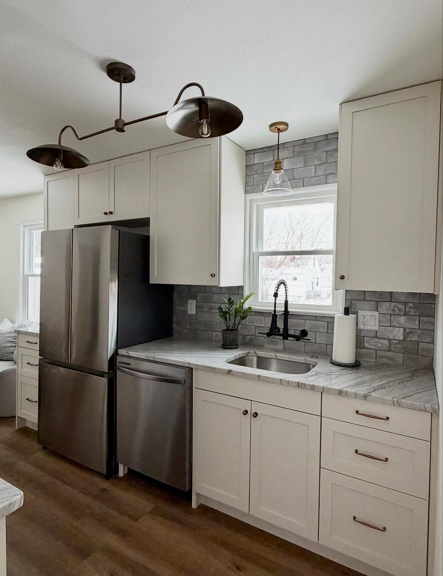 Classic, yet modern. Clean, but cozy. An inviting, timeless kitchen, not too rooted into today’s trends that will stand the test of time.
Richly veined quartzite countertops, variated ceramic tile backsplash to the ceiling, wall mounted pull down faucet, soft-close warm white tall scale cabinetry, antique brass hardware, bespoke lighting full of character✨