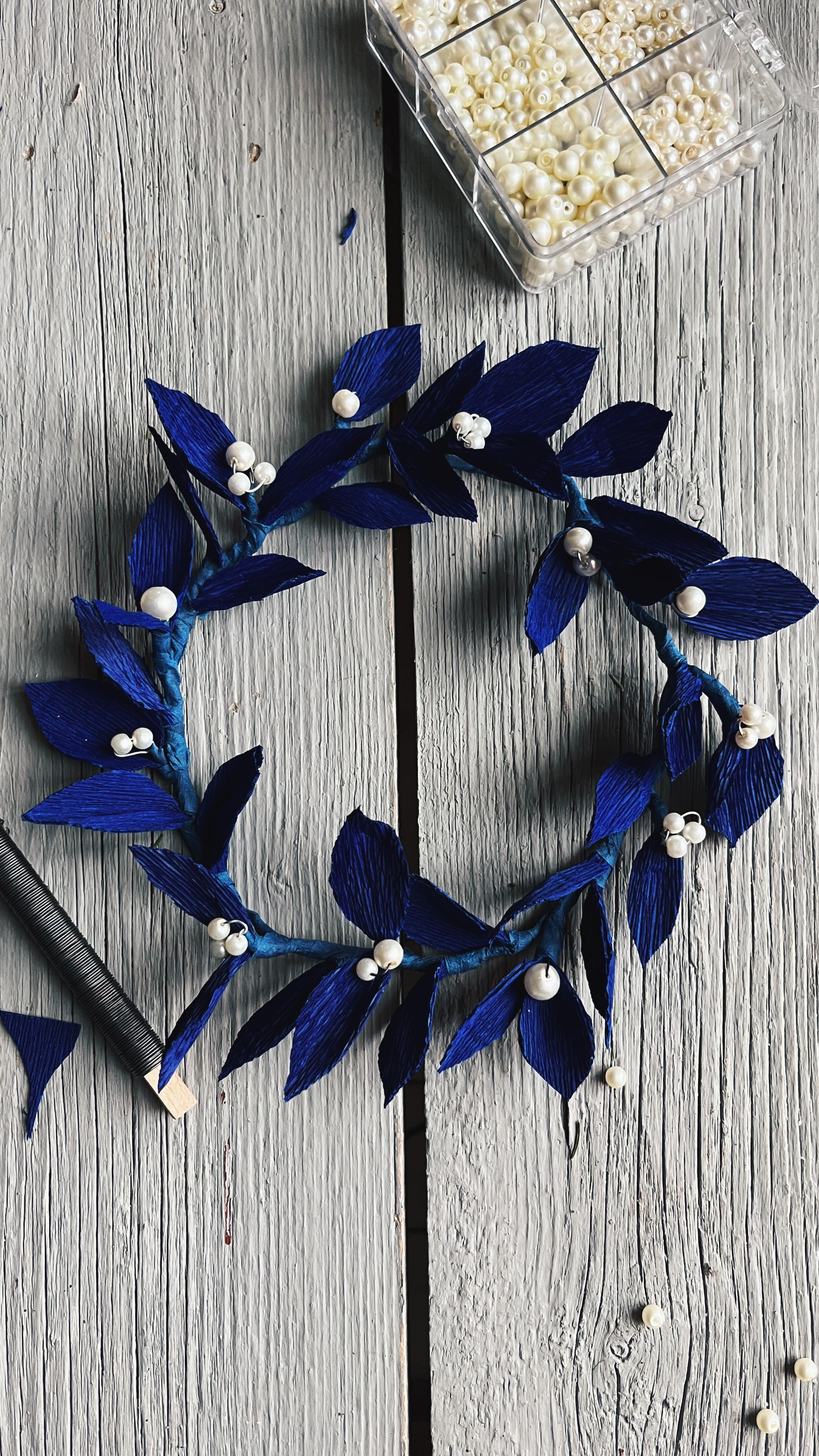 Gjorde denna innan jul och föll sedan in i vinterdvala, men tycker att en sån här vintrig papperskrans funkar även om det inte längre är december.
Till att göra en sån här krans behövs:
Metalltråd
Kräppapper
Floratejp
Limstift
Pärlor