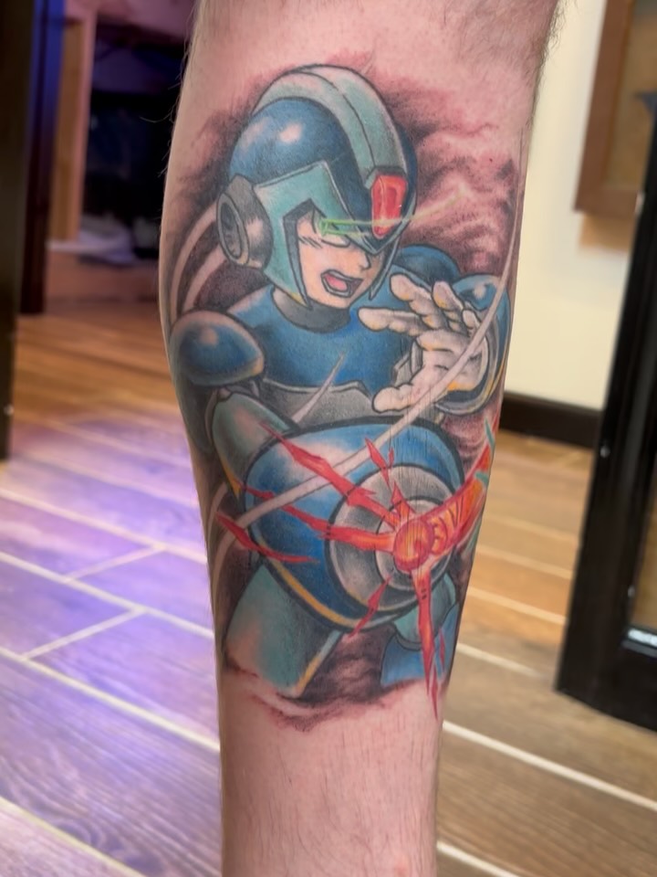 Finally getting around to showing probably my favorite project from 2025! Megaman and Zero in full epic battle mode 💥💥💥 We worked on this in stages over multiple sessions, with this video having the linework/megaman color/most of Zeros color fully healed. The last few pictures I took yesterday of the project fully healed and hairy 😁✨✨ Here’s to more large scale epic anime pieces in 2026… hit me up~ #tattoo #animetattoo #videogametattoo #megaman #megamantattoo