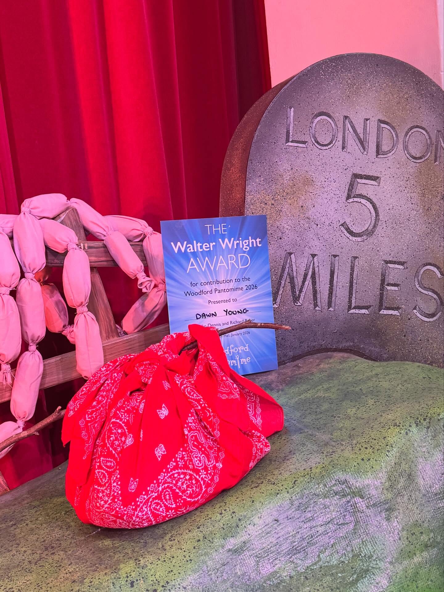 The Walter Wright award is awarded every year for an outstanding contribution for that year’s show. The winner is voted for by the cast, crew and anyone involved in the show.
2026 has been an exceptional year as there is not one, but TWO winners and both are very special.
Our first winner is the late Dawn Young. This year Dawn was organising all the props for the show. Even when unwell in hospital, Dawn’s priority was to still get the props organised and made, including sewing together sausages which you would have seen in the opening scene of the show. Dawn’s passing in December hit the cast and crew hard. She had been a part of Woodford Pantomime and sister company WOADS for over 40 years as a performer, committee member and director. Her wit, kindness and love will be missed but never forgotten and her legacy will live on with the company both on and off stage.
This one is for you Dawn.
Our second winner is Bonnie Young. Bonnie is Dawn’s eldest daughter and was assisting Dawn with the props this year. After Dawn’s passing, Bonnie made it her mission to continue the job that her and her mum had started together. She still came to rehearsals and was at every performance ensuring all the props were where they needed to be, and of course made sure those sausages were set! Bonnie’s grit and determination in what has been the toughest few months for her and the family has been admired by everyone at the company.
Everyone at Woodford Pantomime is so grateful for Dawn and Bonnie. Both are very deserving winners of the Walter Wright Award 2026!