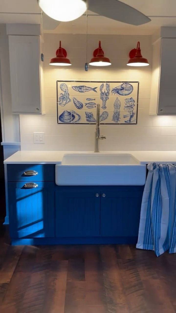 This fun little project started as a mismatched dark brown kitchen. I transformed it into a cheery, bright and inviting space by adding light and bold color.
Duo tone cabinets, tile all the way up, hand-painted tile (by yours truly), bright white farm sink and quartzite countertop, crystal knobs, and polished nickel cup pulls, as well as pops of red; blue and white stripes on the walls, and wainscotting and trim, painted a periwinkle blue, all helped to bring a cohesive coastal vibe to the original kitchen layout.
Install is officially a wrap— next step is to dress her up!
#riinteriordesigner #coastalkitchen #beachcottage