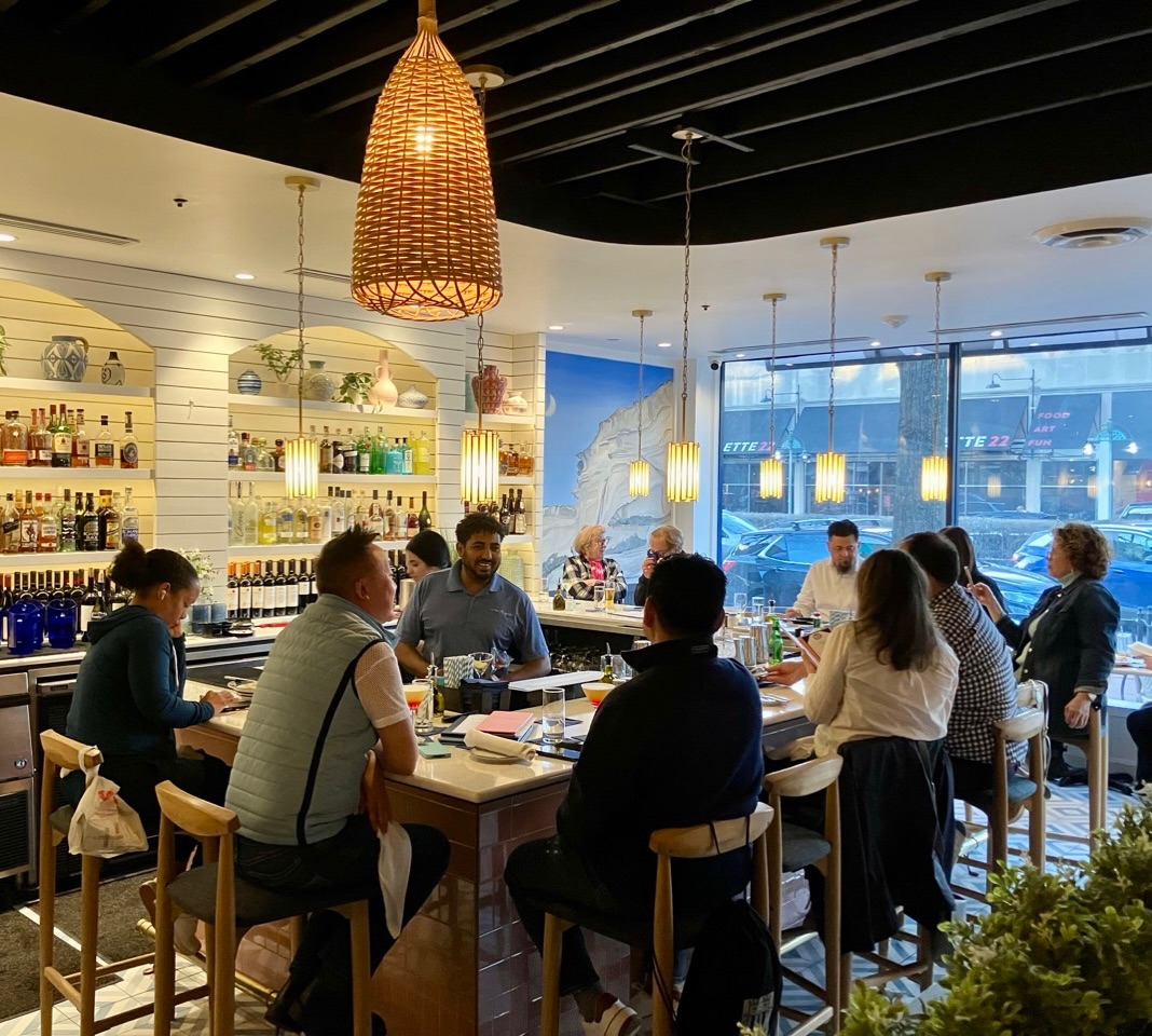 The OME Happy Hour, now available at our Mosaic District location!
After a successful couple of years in Shirlington (pictured above) and thanks to overwhelming guest demand, our happy hour is now officially available at our Mosaic District spot as well!
Happy hour is available weekdays, Monday through Friday, from 4 to 6 p.m., featuring a dedicated food and drink menu available exclusively during those hours.
The menu offers a curated selection of favorites from our regular lineup, served in smaller portions, at happy hour prices, and timed just right for an afternoon bite or early-evening unwind. It is a little bit of everything you love, without the commitment of a full meal.
And of course, there is always a bartender on duty, ready to pour libations of all persuasions. As you probably know, our bar in Mosaic is quite cozy, so a couple of neighboring tables will also be available for happy hour guests.
See you at the bar and APOLAFSTE YPEFTHYNA (that’s ENJOY RESPONSIBLY in Greek)!