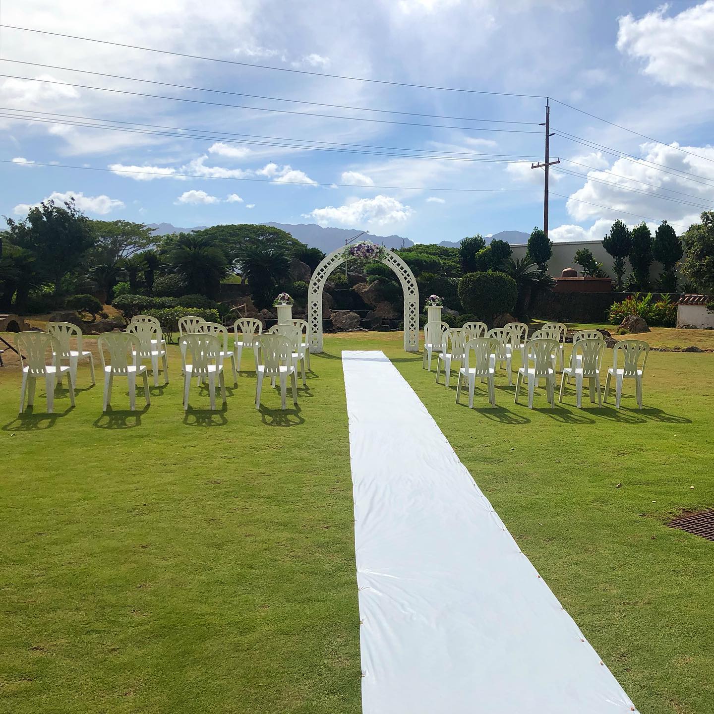A simple ceremony setup done right outside the Hawaii Okinawa Center.
This venue already provides a white lattice arch that can easily be adorned with flowers by your florist or coordinator (us!). The venue staff also provides side columns, chairs and an aisle runner.