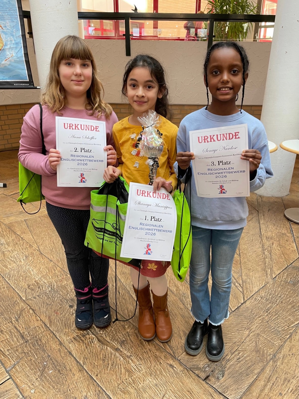 Whose English is best?
GrundschülerInnen zeigen Ihr
Können beim Regionalen Grundschulwettbewerb in
Kirchberg
Am 15. Januar 2026 fand der Regionale Grundschulwettbewerb Englisch zum 21. Mal am
Christoph- Graupner- Gymnasium Kirchberg statt. Dieses Jahr nahmen 104 Schüler und
Schülerinnen der Klassenstufe vier aus 56 Grundschulen der Regionen Vogtland, Zwickauer
Land und Erzgebirge am Wettbewerb teil. Sie gelten an ihrer Schule als die besten
Englischlernenden der vierten Klassen.
Die TeilnehmerInnen und deren Begleitpersonen wurden zunächst durch Frau Steinert, der
Schulleiterin des Christoph-Graupner-Gymnasiums, begrüßt und von Lernenden der
Klassenstufe fünf mit einem abwechslungsreichen Programm und englischen Liedern auf den
Wettbewerb eingestimmt. Anschließend konnten die GrundschülerInnen ihre
Englischkenntnisse anhand verschiedenster Aufgaben zum Hör- und Leseverstehen sowie zu
englischem Wortschatz und Landeskundewissen unter Beweis stellen. Gestärkt mit einem
Mittagssnack erhielten im Anschluss alle die Möglichkeit, die Schule bei einer Rallye näher
kennenzulernen und an verschiedenen Freizeitangeboten teilzunehmen. Hier konnten sie die
Gelegenheit nutzen, mit Playmobil ins Mittelalter zu „reisen“, ihre Geschicklichkeit unter
Beweis zu stellen, die spanische Sprache kennenzulernen, mit verschiedenen Instrumenten
zu musizieren, zu würfeln oder wie die Großen zu experimentieren.
Ein gelungenes Ende fand der Wettbewerbstag durch die Auszeichnung der besten
Englischlernenden, deren Ergebnisse eng beieinander lagen.
So erzielte Senaye Nardose (Nicolai-Grundschule Zwickau) einen tollen dritten Platz. Den
zweiten Platz erreichte Anna Scheffler (Grundschule Wildenfels). Als Siegerin konnte sich
Shanaya Maniappan (Grundschule Theuma) gegen alle anderen
WettbewerbsteilnehmerInnen durchsetzen und den von der Stadt Kirchberg gespendeten
Pokal mit nach Hause nehmen.
Wir freuen uns, alle Schülerinnen und Schüler sowie weitere Interessierte zum Tag der offenen
Tür am 24. Januar 2026 wieder bei uns begrüßen zu dürfen.
#grundschulwettbewerb #englisch #graupnergym