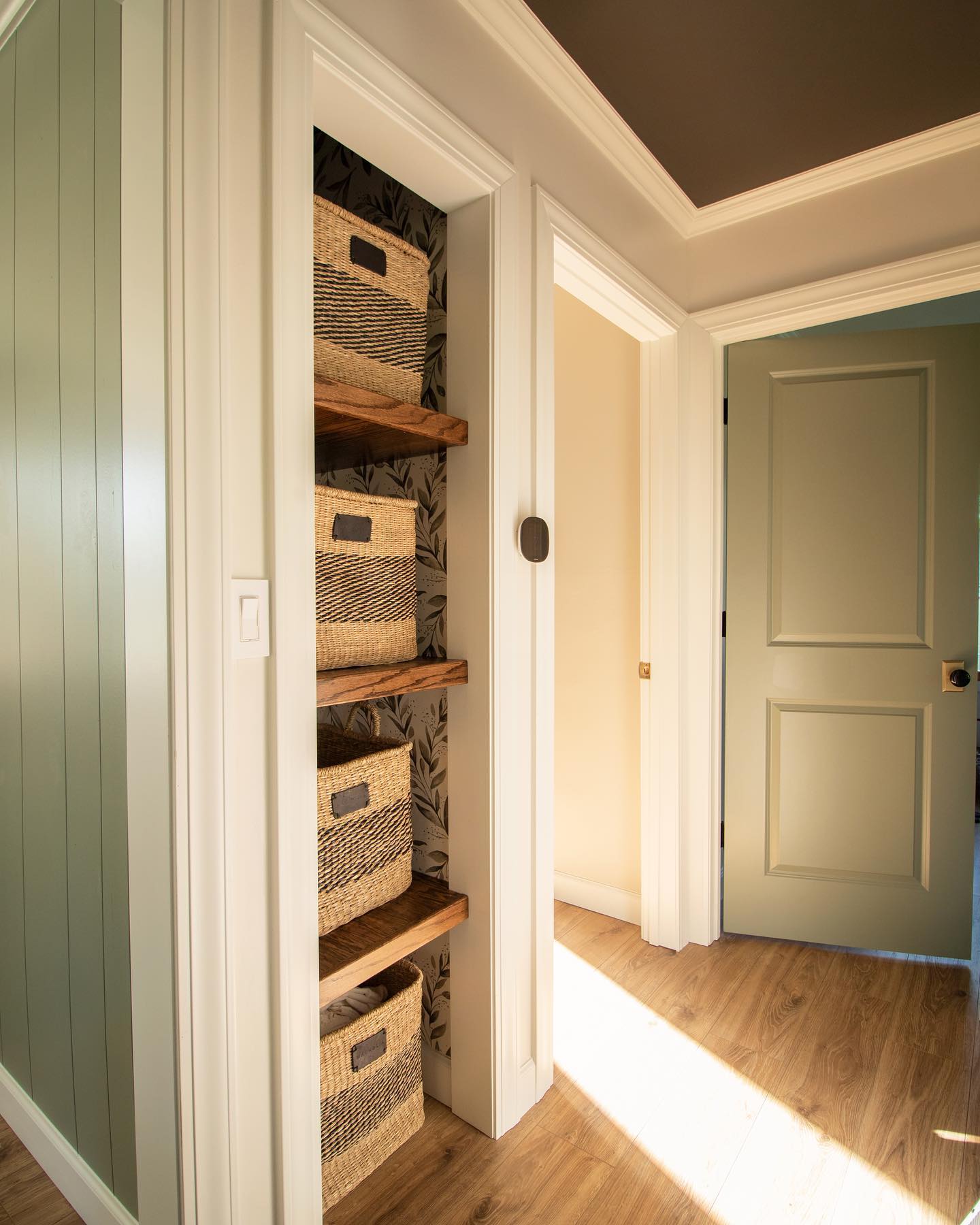 Wanna know more about how we built these floating shelves? Check back tomorrow for more info 😉 Side note, this hallway is so difficult to photograph, either the shadows are too dark or there’s a doorway to heaven 🤷🏻♀️🙏🏼🤪
.
.
.
#jessiesinteriors #interiordesigner #interiordesign #hallwayinspo #hallwaydesign #floatingshelves #wallpaper #linencloset #urbanebronzesherwinwilliams #magnoliahome #ecobee #paintedceiling #painteddoor #evergreenfog #greenpaint #woodshelves #storagebaskets #wovenbaskets #diyprojects #hallwayremodel #laminateflooring #loveyourhome #hgtv #linenclosetorganization #linenclosetgoals