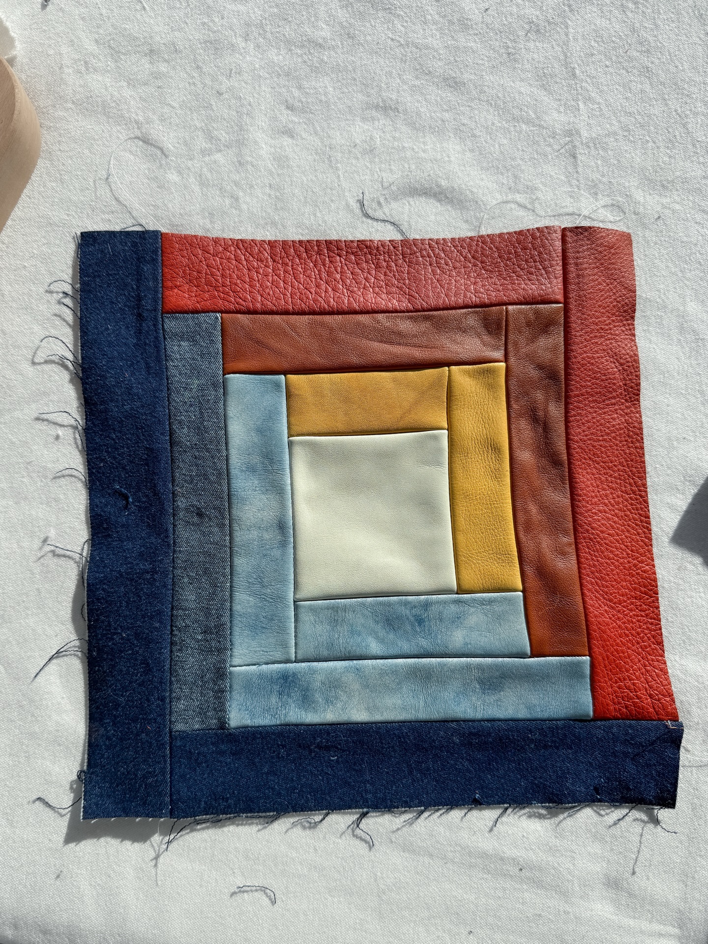 The log cabin got another layer. I decided I want to be better about sharing the “ugly” stages of each project. The part where things look wonky and uneven, seams are bunchy, or the vision isn’t clear.
Because it happens in every project, and it’s generally when doubts creep in and projects are abandoned. So I thought I’d share, in case there are people out there who are just starting out, so you can see it’s a perfectly normal part of the process 😅.
I could look at this block and decide the seams are just not going to behave, that the leather was too thick for this design. But instead I’m thinking of how I solve this – better glue, an iron (carefully with a press cloth) or more likely some well-placed topstitching.
Normally I’d have added a topstitch already, but this might be quilted so I have to save it 🤔. We will see!