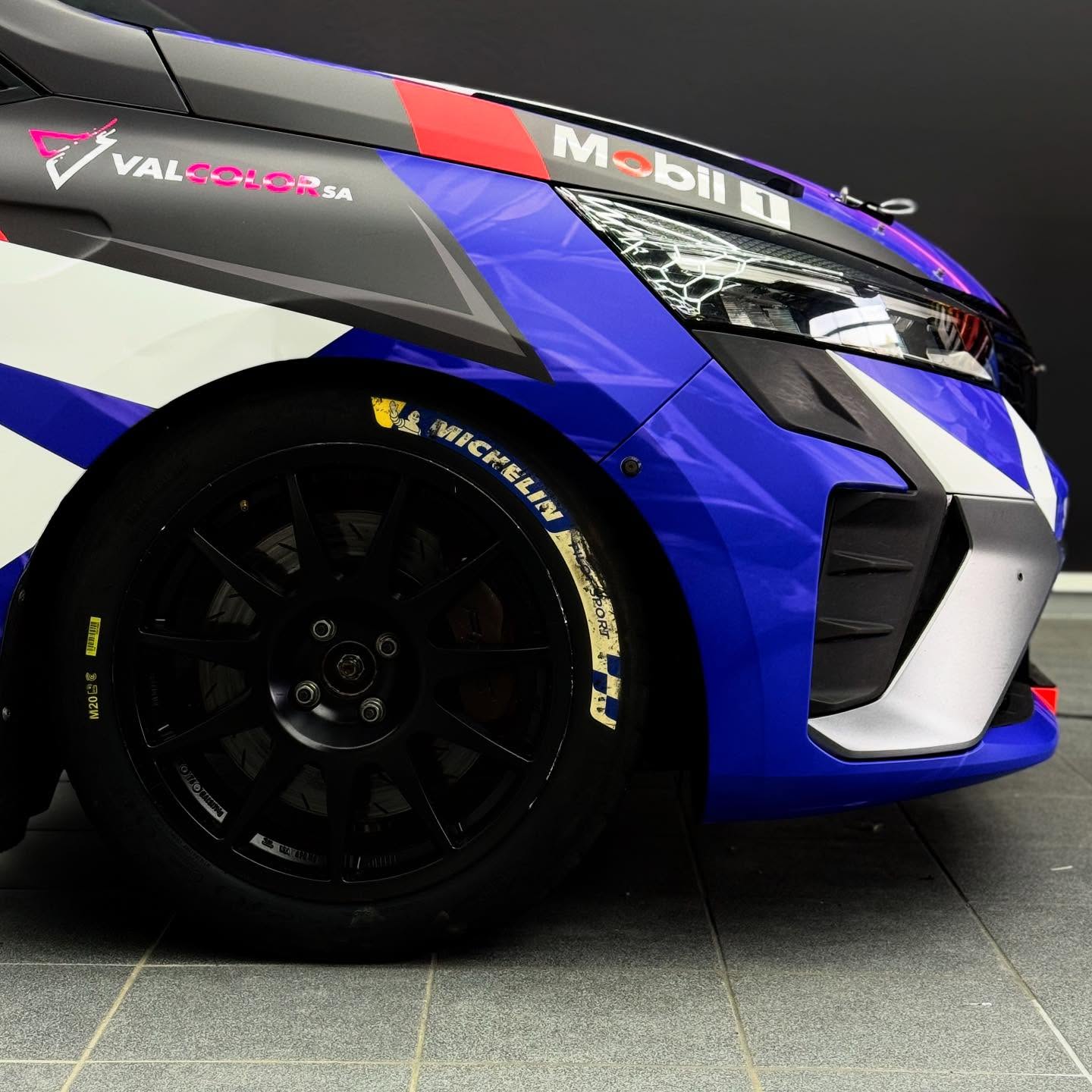 Réalisation de la pose complète d’un covering mat sur une voiture de rallye, avec une attention particulière portée à la qualité d’application et à la durabilité en conditions de compétition.
La finition mate a été choisie pour ses propriétés anti-reflets, sa lecture homogène des surfaces et son rendu sobre et technique. La pose a nécessité une préparation minutieuse du véhicule, incluant le nettoyage approfondi, le dégraissage et le démontage partiel de certains éléments afin de garantir des raccords discrets et une tension maîtrisée du film.