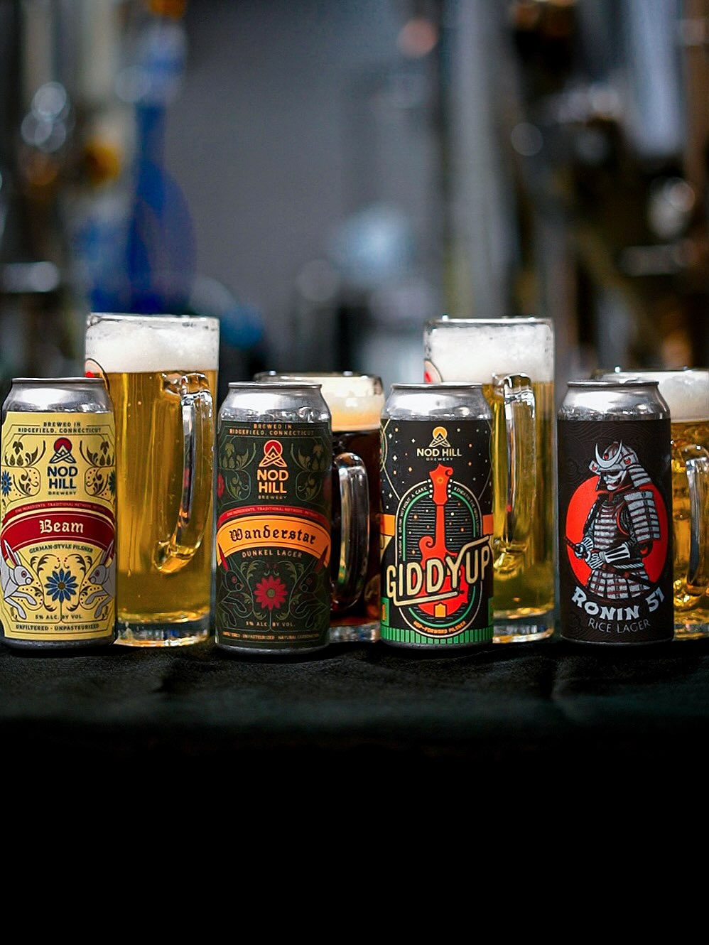 The Nod Hill Lager Program, and the Kräusen Lager.
Many of our lagers at Nod Hill are finished using kräusening, a traditional German method of natural re-fermentation that allows the beer to come together the way it’s meant to.
Instead of forcing carbonation, we introduce a small amount of fresh, actively fermenting wort near the end of the process. That renewed fermentation creates carbonation naturally, giving the beer a softer, rounder mouthfeel and a finer, more textured carbonation. It also brings a subtle fresh grain character that ties the beer together in a way no other method can.
Kräusening takes more time, more coordination, and more hands-on work in the cellar—but those choices are intentional. Our dedication to quality drives how we make beer, even when the harder path is the better one. The result is lagers that drink smoother, feel more complete, and reflect our commitment to delivering the best possible beer every time.