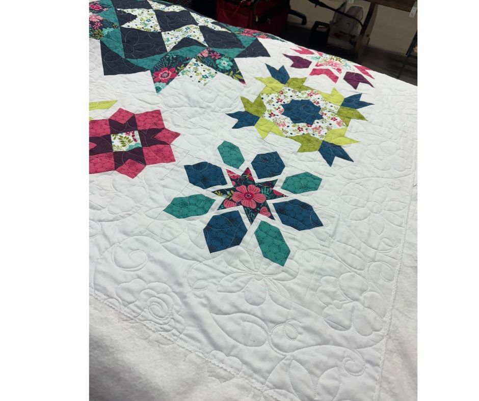 Secret Garden Quilt has returned from the quilters. What an amazing job she has done. I went with an edge to edge design as I didn't want to distract from the blocks.
Time to put on the binding. The patterns say to put a dark navy as the binding but think I will put on a white binding.
Don't forget we are offering this quilt as a Block of the Month and have kits ready to go!