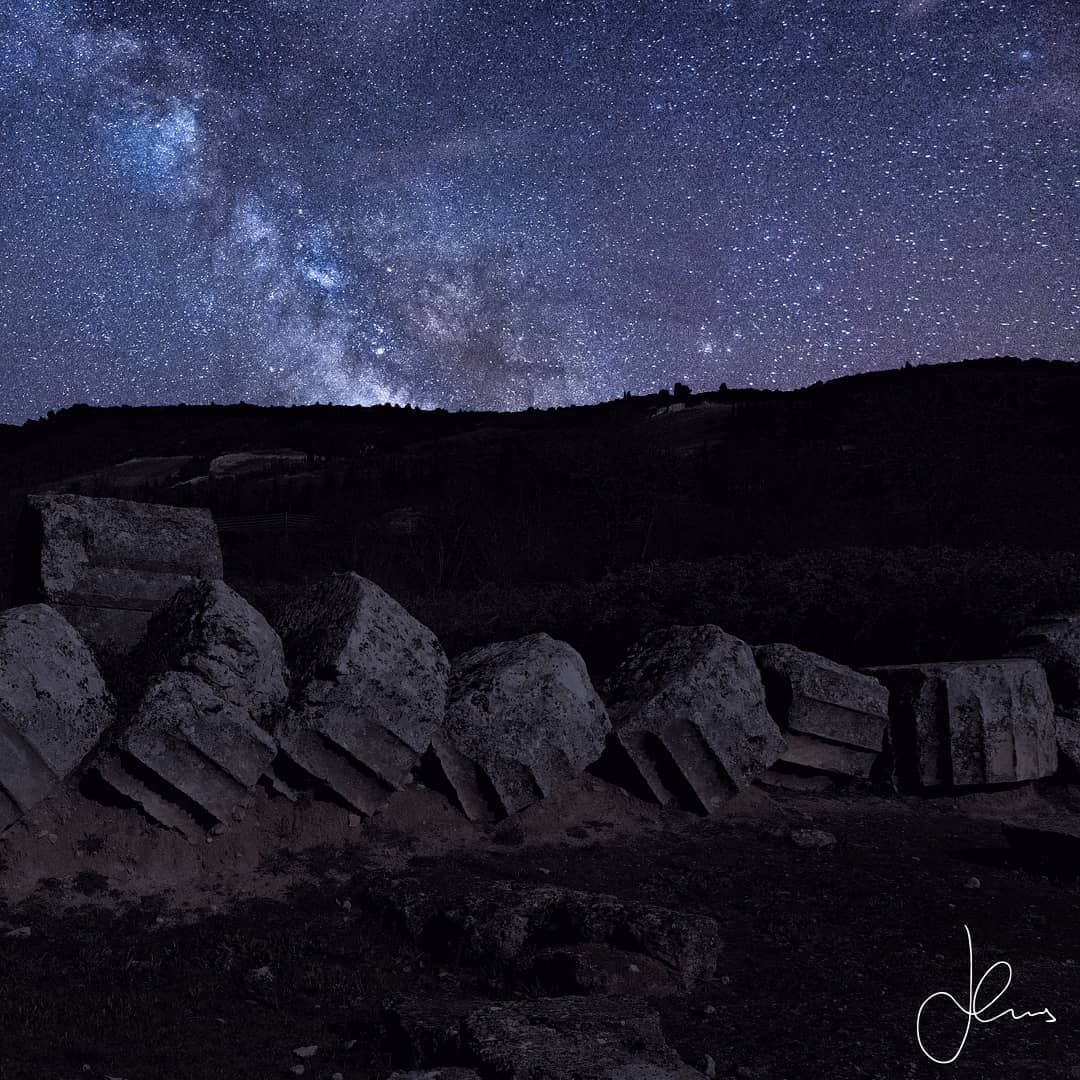 🏺🏛❗Three columns have survived from the original Temple of Nemean Zeus (330 BC) with an ongoing reconstruction project going on that has added to the original three another two columns in 2002 and four in 2012 (9/34 original visible columns). In this photo we witness a column on the ground, it reminds me of a sliced marble salami and highlights the construction process where these segments (“marble drums”) were held together with wood (and then metal) pegs. It was the love and devotion of the American professor Dr. Stephen Miller from UC Berkeley who started the extensive excavation on the site of Ancient Nemea in 1973 who was subsequently able to secure the private donations necessary that finally led to these columns being re-erected as well as constructing an archaeological museum on the site (1984). Dr. Miller was very fortunate as today he lives in Nemea with his Greek American wife and still visits the continuing archaeological work.
◾◾◾
Looking at the ethereal heavens I was reminded that Ancient Greek temples where generally astrologically oriented towards the rising sun (predominant east-west alignment). Recently a study (2015) concerning the Greek temples in the UNESCO site in Agrigento, Sicily has proposed that on that specific site there are temples aligned to the moon and the constellations which is unusual and made me ponder how ancient architects looked at the night sky for inspiration of the divine structures they designed. *Disclaimer: I “made” this photo it would look exactly like this but ideally, you would have to photograph the Milky Way in July (it wouldn’t be visible in Greece in January), the night pollution in Ancient Nemea is minimal and you would have to get permission to be on the site at night and for the temple not to be lit temporarily! I hope I can secure permission in the future!
◾◾◾
❗Date of Visit: Jan 10, 2020 Weather Conditions: Noon visit on a wonderful winter Friday – The climate in Nemea (357m above sea level) is especially mild and the mountainous landscape creates the perfect “pocket” for cultivating grapes. Today many producers create excellent robust red wine based on the Greek grape variety "Agiorgitiko"