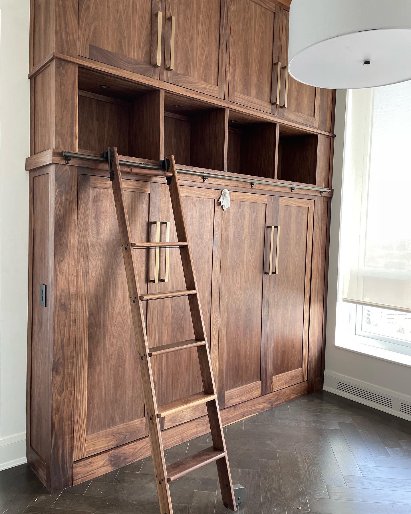 11’ tall cabinet in walnut with queen Murphy bed stowed away. Library ladder to reach upper cabinets.