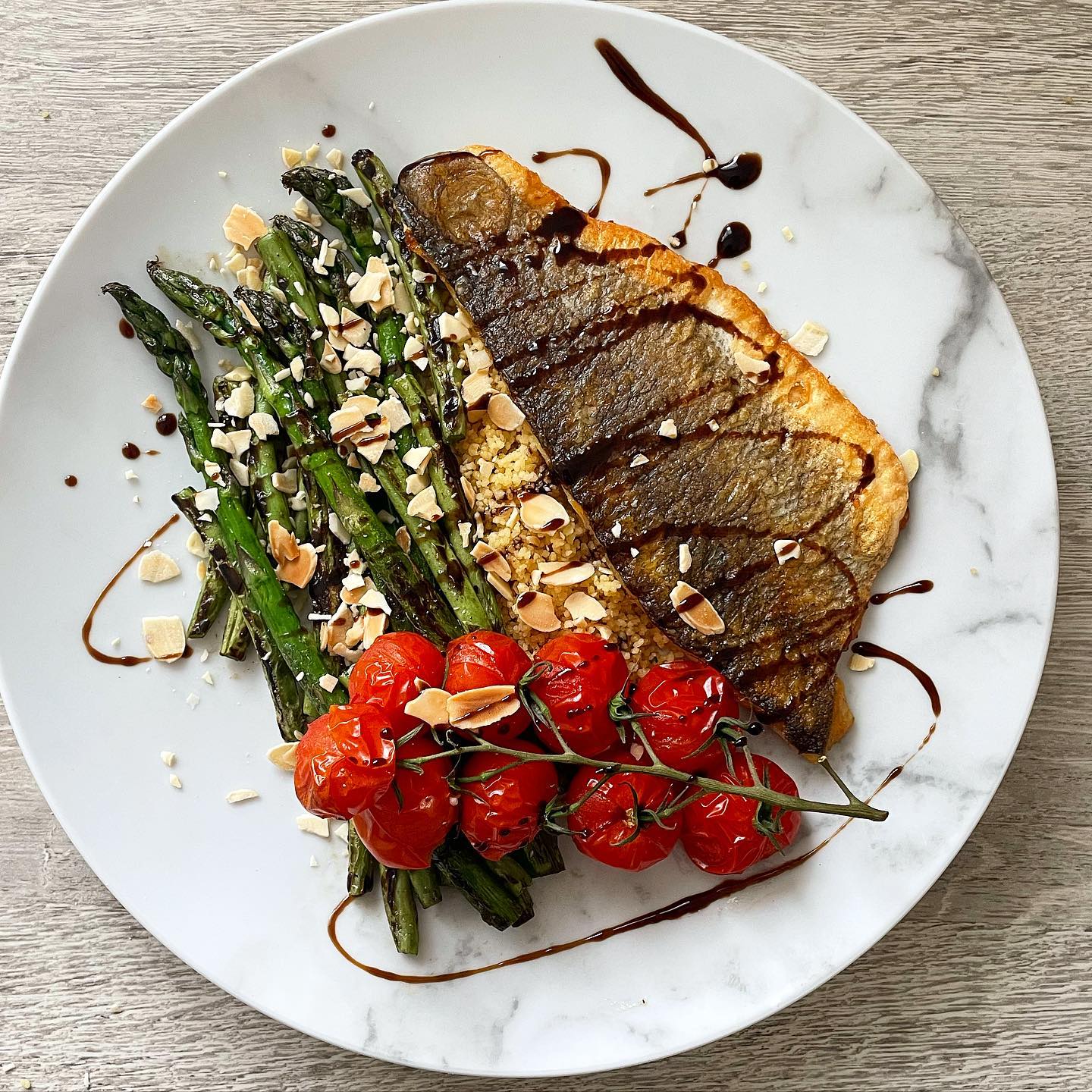 Pan fried seabass, asparagus, brocolli, cous cous and roasted vine tomatoes, topped with toasted almonds and drizzled with balsamic👌