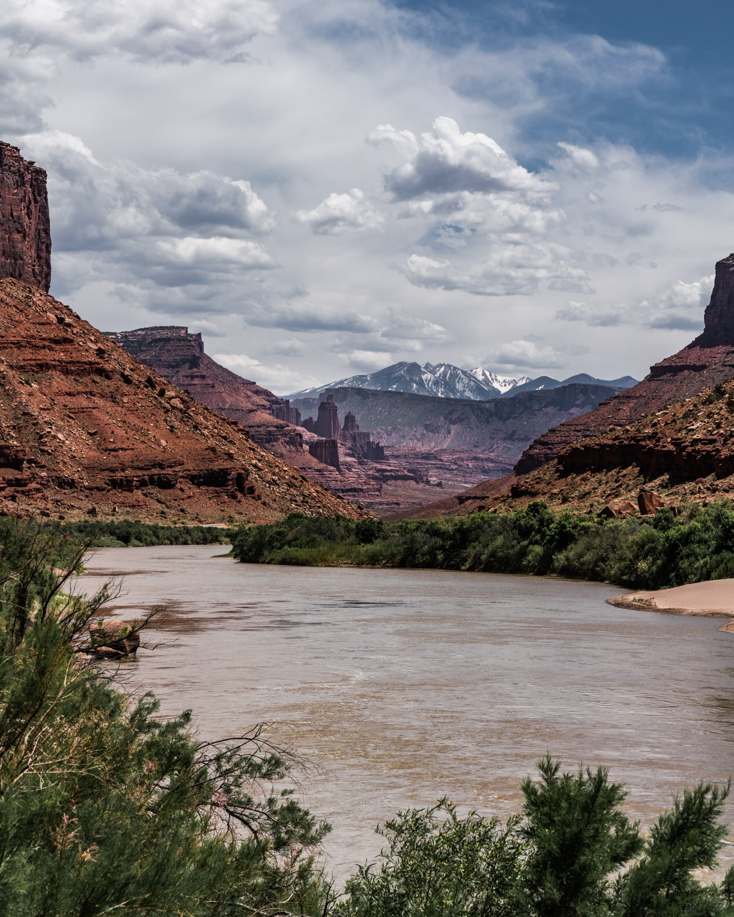 No matter how many times I pass through this spot near Fisher Towers, it never becomes “normal.”
Desert. River. Red rock canyons. Snow-capped mountains. Green riverbanks.
It shouldn’t all exist in one place, but it does.
And it still takes my breath away every time!