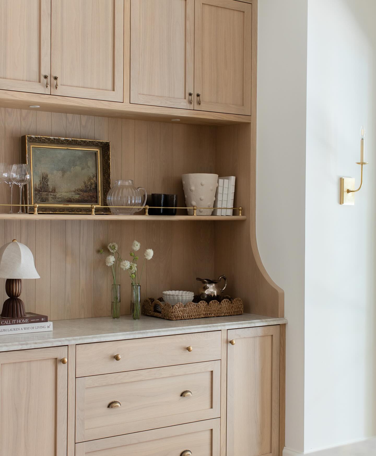 We aimed to give this new home’s kitchen niche a bit of an old world feel by designing the millwork with details of a free standing hutch: swooping side gables, profiled stone edge, brass shelf rod, and teardrop finger pulls. #oldworldnewhome
