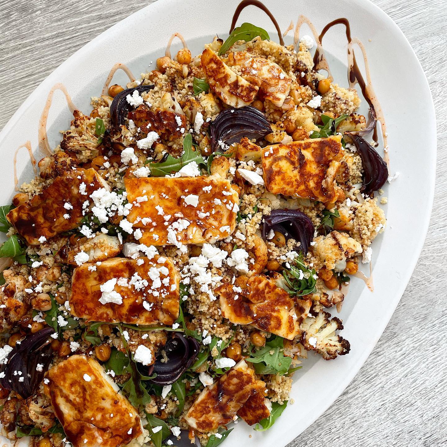 Honey, sriracha and balsamic halloumi, roasted red onion, chickpeas, cauliflower, rocket and feta cous cous 💫 So much goodness on one plate 💚