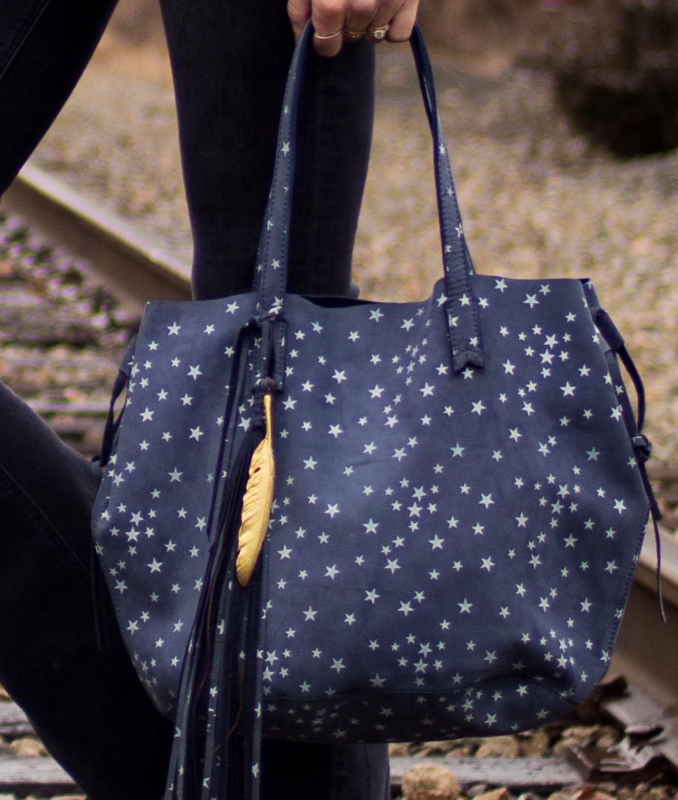 Rolling into the Holiday Weekend with ✨The Starry Tribe Tote✨ Our dreamy slouchy tote is the perfect carryall. The Tribe is super versatile and can be cinched at the sides to create a slim silhouette. Adorned with our signature Dove feather, stitched arrow detail and a killer long tassel for just a touch of fringe. ✨Welcome to the tribe.✨#rockandstone #tribetote #nubuck #stars #softtote #happy4thofjuly
