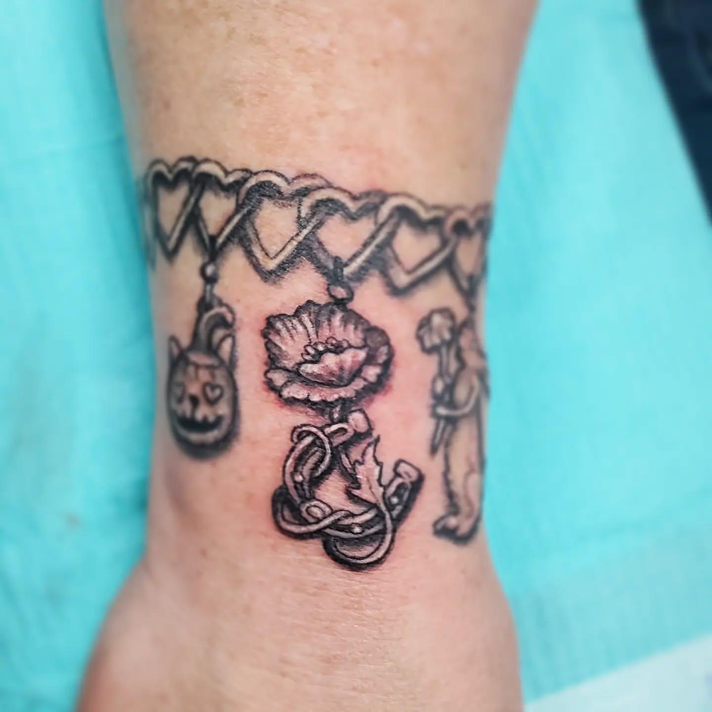 @jeffcooktattoos added a poppy and horseshoe charm to Dee's charm bracelet paying tribute to her family. Stop by our awesome neighbours at @thehappycannaseur and see it in person!
