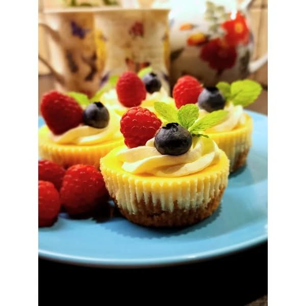 Mini cheesecakes topped with cream & fresh berries