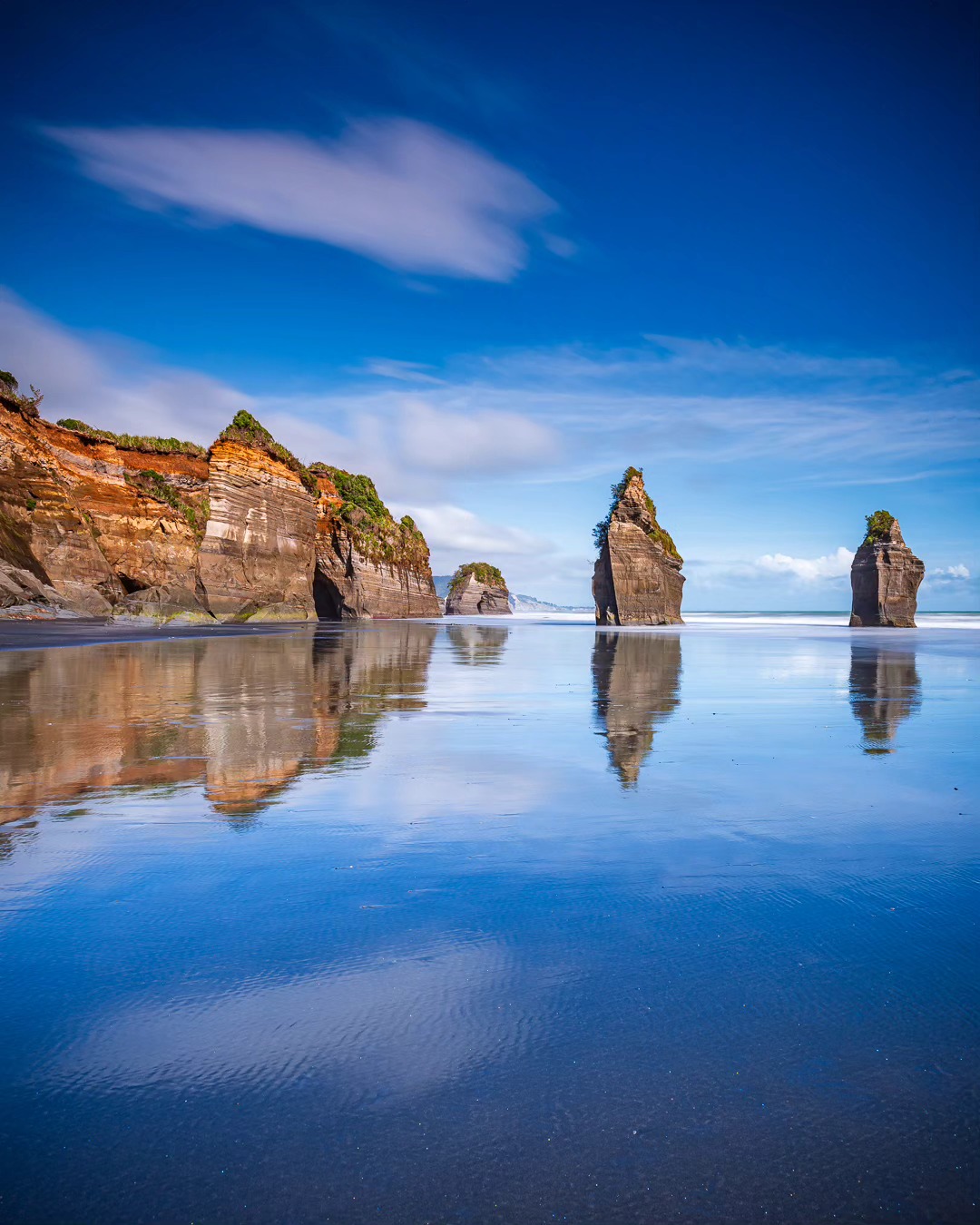 Happy Earth Day 🌏 Reflections at the Three Sisters and Elephant Rock in Taranaki, New Zealand (sadly, the third sister and the elephant's trunk were claimed by the sea).