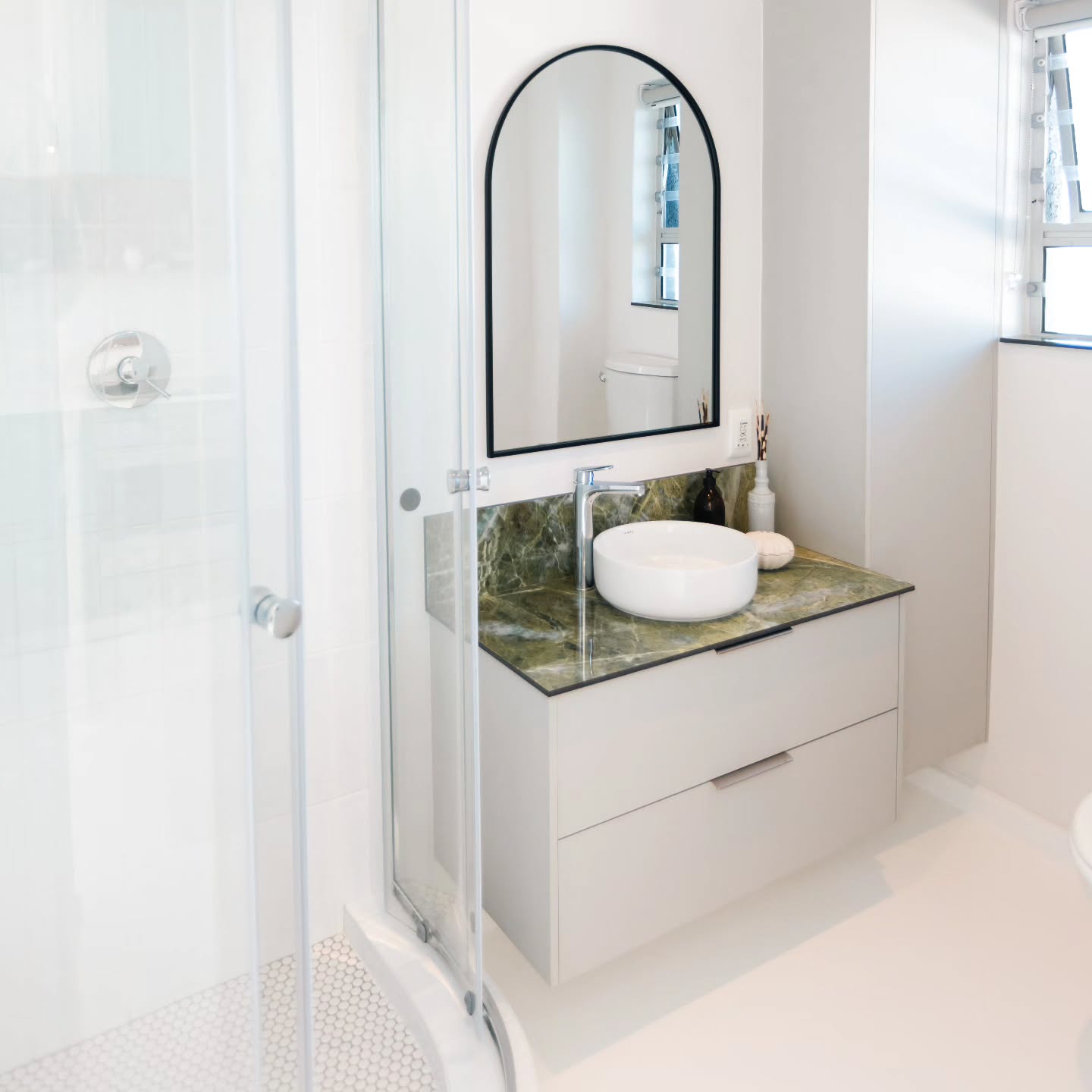 This bathroom vanity pairs clean storage with a striking Irish Green porcelain slab, creating a refined focal point.
The sleek drawers offer generous concealed storage, while the rich green veining of the porcelain adds depth and natural elegance against the crisp, minimalist cabinetry.