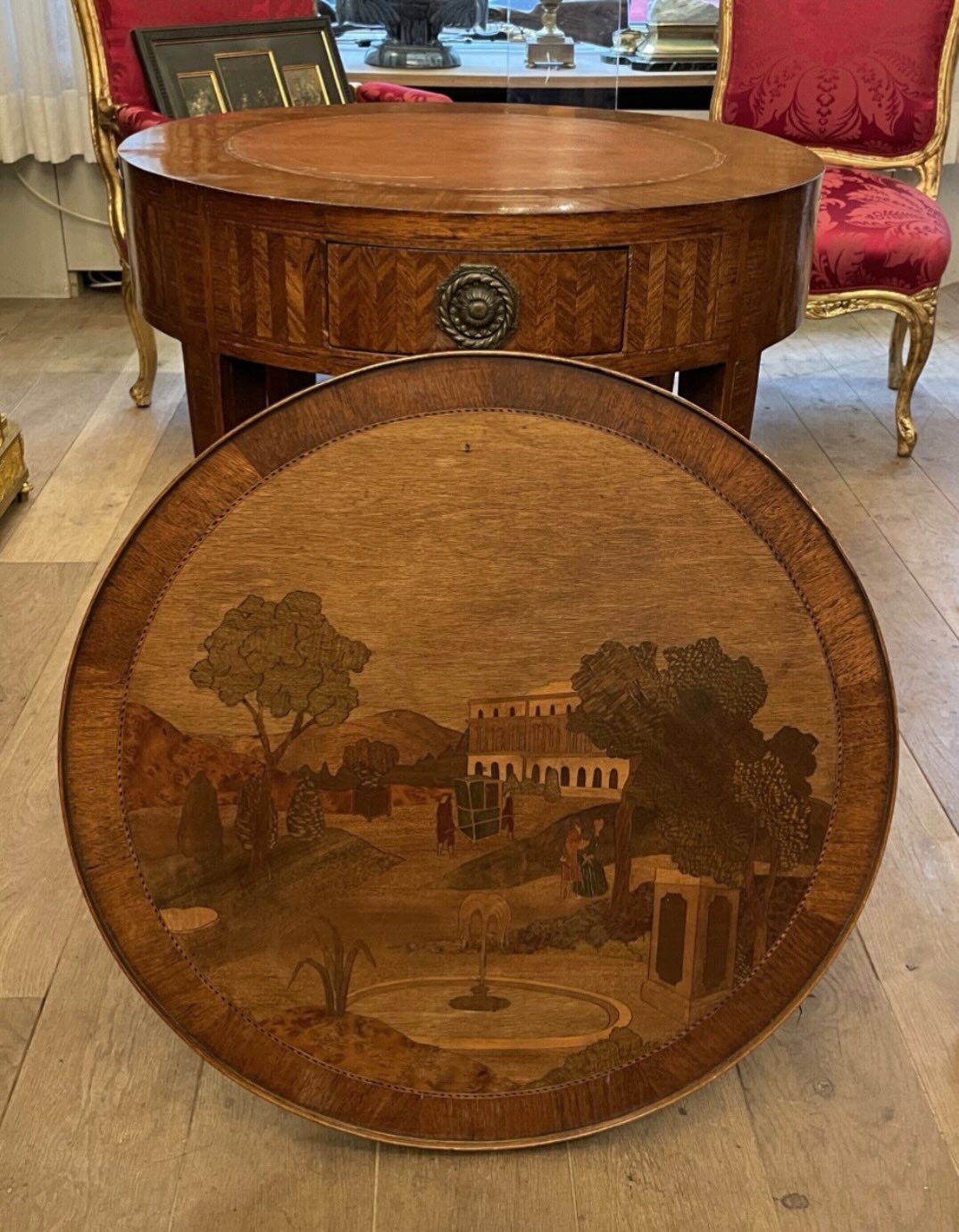 Louis XVI Bouillotte Table in Precious Wood, Reversible and Convertible
This bouillotte table stands out for its reversible and convertible top, revealing two different game surfaces:
• A decorative panel featuring architectural and landscape motifs.
• A chequerboard panel, ideal for board games.
The main tabletop is fitted at its center with the original fawn-colored leather, surrounded by a gallery (lingotière) designed to hold playing cards, gaming counters, and accessories.
The table further features three different interchangeable tops.
It rests on four tapered legs ending in bronze sabots, characteristic of the Louis XVI style.
The piece is equipped with two frieze drawers as well as two pull-out slides.
The refined geometric marquetry, delicately chased bronze mounts, and harmonious proportions reflect a high level of cabinetmaking craftsmanship, typical of French production from the late 18th century.
Louis XVI period, circa 178 #yesterdayknuts #antique #antiquedealers #homedecor #homedesign