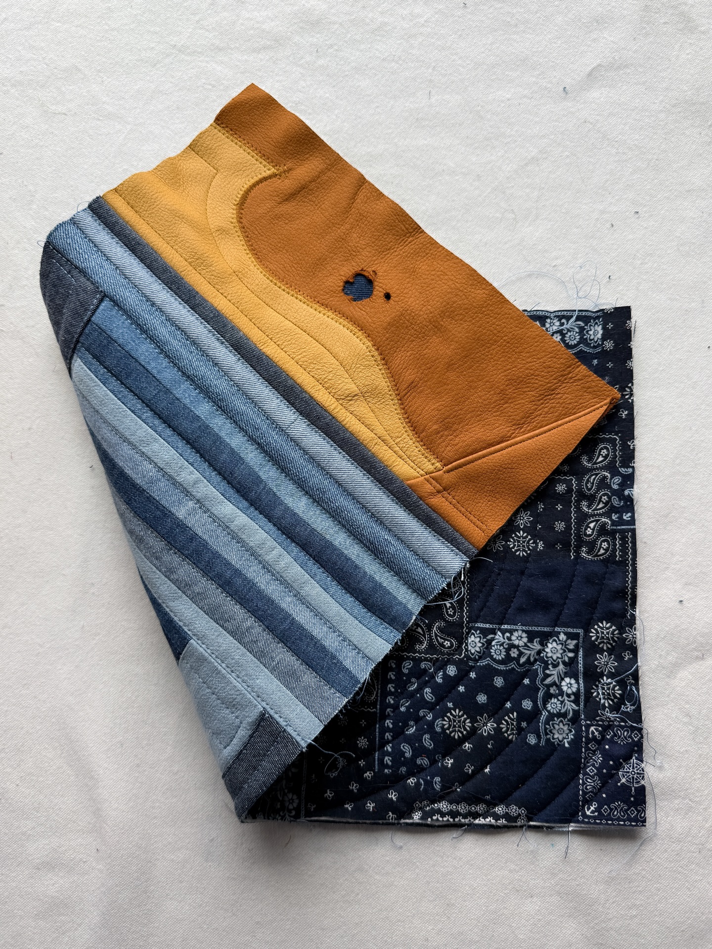 It’s another (not requested) episode of how my brain works. Subject: making small functional things from leftover materials from a previous project using a technique I’ve never used is my emotional support activity. Yes I know, it’s kind of specific, but it’s a thing.
The functionality part is because I need to feel like I’m accomplishing something worthwhile and not frivolous (I’m not saying your non-functional items are frivolous, just mine, it’s just a thing with my brain, don’t ask).
The leftover materials from another project are the puzzle - how do I take this rectangular thing made of denim strips and curves and turn it into whatever (in this case a rolled case for hand-sewing tools). It’s also my impatience because it means the project is already half done.
The fact that it needs to be a small item is due to the already mentioned impatience.
The new technique part: I’ve never done leather binding in this way, and I’ll be adding leather pockets and strips to secure the tools which I haven’t done. This is the critical part, the science experiment. I don’t enjoy repetition, I don’t enjoy perfecting or creating small iterations, I enjoy the exploration. Wondering what will happen if…
So… yep. I’m making a denim and leather quilted roll case for my hand-sewing tools. I’m pretty happy with how it’s going. Also done forget to abolish ICE.