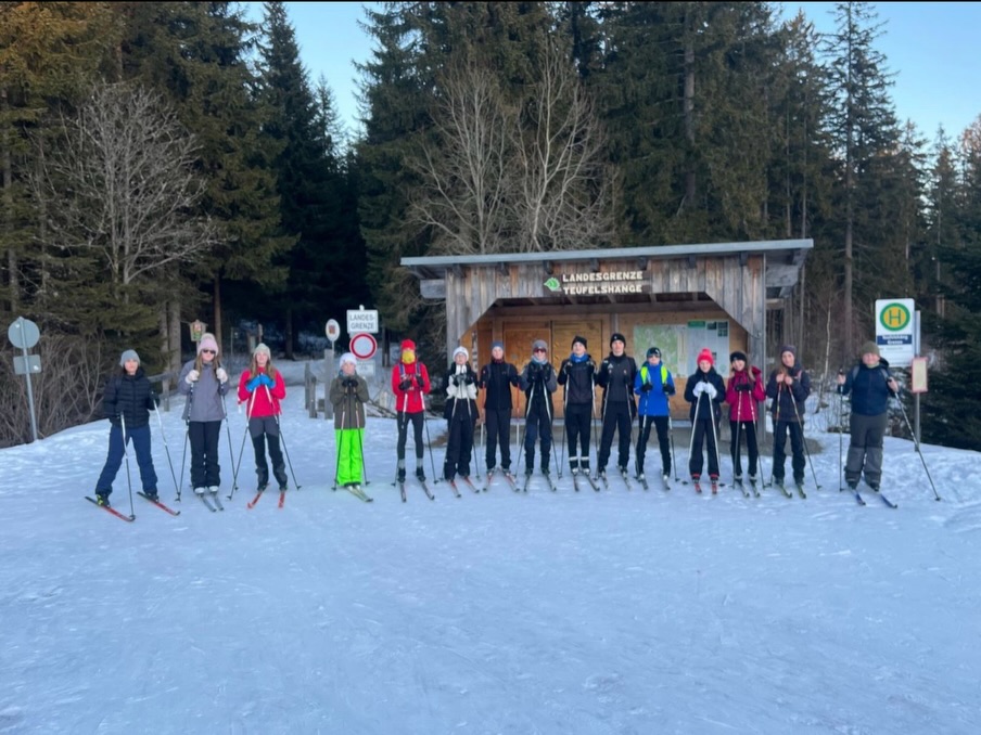 Skilager 2026 ⛷️❄️ – unser Wochenrückblick
Am Sonntag (18.01.) ging’s um 11:11 Uhr in Kirchberg los. Nach einem kurzen McDonald’s-Stopp (13:30 😄) fuhren wir weiter zum Landgasthaus Krückl. Koffer abladen, direkt weiter zur Skiausleihe – und abends gab’s zur Belohnung Spaghetti Bolognese. Danach Zimmer beziehen und 21:30 Bettruhe.
Montag (19.01.): Frühstück um 8:00 Uhr, dann ab zum Sportplatz. Viele standen dort zum ersten Mal auf Skiern, also hieß es: Grundlagen üben, fallen, lachen, wieder aufstehen 😅 Mittags Lunchbox, danach die erste kurze Tour – nicht perfekt, aber wir wurden besser. Abends: Pommes & Schnitzel. Und dann wirklich das Highlight der Woche: Polarlichter um 22:30 Uhr am Himmel – einfach nur wow ✨
Am Dienstag (20.01.) ging es „richtig“ in die Loipe und mit dem Bus ins nächste Skigebiet. Dort trafen wir auch die Abfahrer aus unserer Klassenstufe. Wir wurden in zwei Gruppen eingeteilt und fuhren unterschiedliche Touren. Am Nachmittag haben wir das Bremsen weiter geübt und dann gemeinsam eine große Runde gemacht – über Hügel und durch richtig schöne, fast märchenhafte Wälder 🌲 Zum Abendessen: Spätzle & Hähnchenschnitzel.
Mittwoch (21.01.) startete… sagen wir mal… sehr abrupt: Eine „nicht namentlich genannte Person“ riss alle mit einem knarzenden Schrank aus dem Schlaf 😭 Danach ging’s wieder in ein neues Skigebiet – mit perfekten Bedingungen! Erst Sportspiele auf Skiern, dann sogar zwei Runden auf einer Rennloipe 🏁 Abends gab’s Klöße mit Kartoffelbrei.
Donnerstag (22.01.) war mal anders: Wir fuhren nicht wie sonst um 9:00, sondern erst um 11:00 Uhr los. Davor stand ein Spiele-Vormittag an. Danach ging’s wieder auf die Loipe, Touren fahren – und der krönende Abschluss: die Nachtloipe. Im Dunkeln durch den beleuchteten Wald zu fahren war einfach ein unvergessliches Erlebnis 🌙💡
Am Abreisetag saßen wir um 8:30 Uhr wieder im Bus und waren um 14:00 Uhr zuhause – mit müden Beinen, viel Schlafmangel, aber mega Erinnerungen ❤️
Von:
• Luca
• Simon
• Lennard
• Jared
• Manuel
• Leoni
#Skilager2026 #SkiTrip #Klassenfahrt