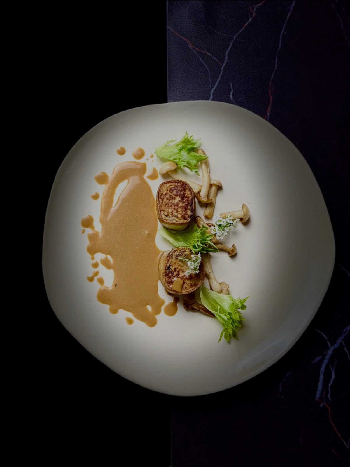 La carte du Soir - la saison de Dàhán
【Blancs de Saison, Douceur Naissante|时白暖益】
❄️ Le Grand Froid s’attarde encore, mais sous la feuille de tofu 🍃, la douceur se recueille.
🍗 La mousse de poulet, tiède et soyeuse, garde la mémoire de l’hiver.
🍄 Les champignons shimeji blancs, purs comme la neige 🤍, portent la fraîcheur du froid et la promesse du printemps 🌸.
🌬️ À l’approche de Lichün, la chaleur s’éveille doucement ; avec Yushui 🌧️, la sauce au poulet et aux champignons coule, fine comme une pluie de saison, nourrissante et légère.
🍽️ Un plat de passage, où l’hiver se retire sans bruit 🤫 et où la vie recommence 🌱.
📜 Connu autrefois sous les noms de « champignon blanc » ou « xùn de jade », le shimeji blanc n’était pas un grand « trésor des montagnes » ⛰️, mais il a trouvé sa place, dès les dynasties Ming et Qing 🏯, dans la cuisine chinoise quotidienne et végétarienne 🧧.
✨ Apprécié pour sa texture croquante et sa saveur délicate, il incarne une esthétique culinaire de la pureté et de la retenue. 🤍 Il absorbe les sucs sans les dominer, ce qui en fait un compagnon idéal des volailles 🍗 et des produits de soja 🌾.
🌓 Dans la logique des vingt-quatre termes solaires, le shimeji blanc est considéré comme un ingrédient « neutre » ⚖️, parfait pour la période charnière entre la fin de l’hiver ❄️ et la naissance du printemps 🌸 — un aliment qui prépare le corps à renaître en douceur 🌱.
📝 Réservation : www.bistrowu.com
#aix #aixmaville #aixenprovence #aixenprovence❤️ #aixmarseille