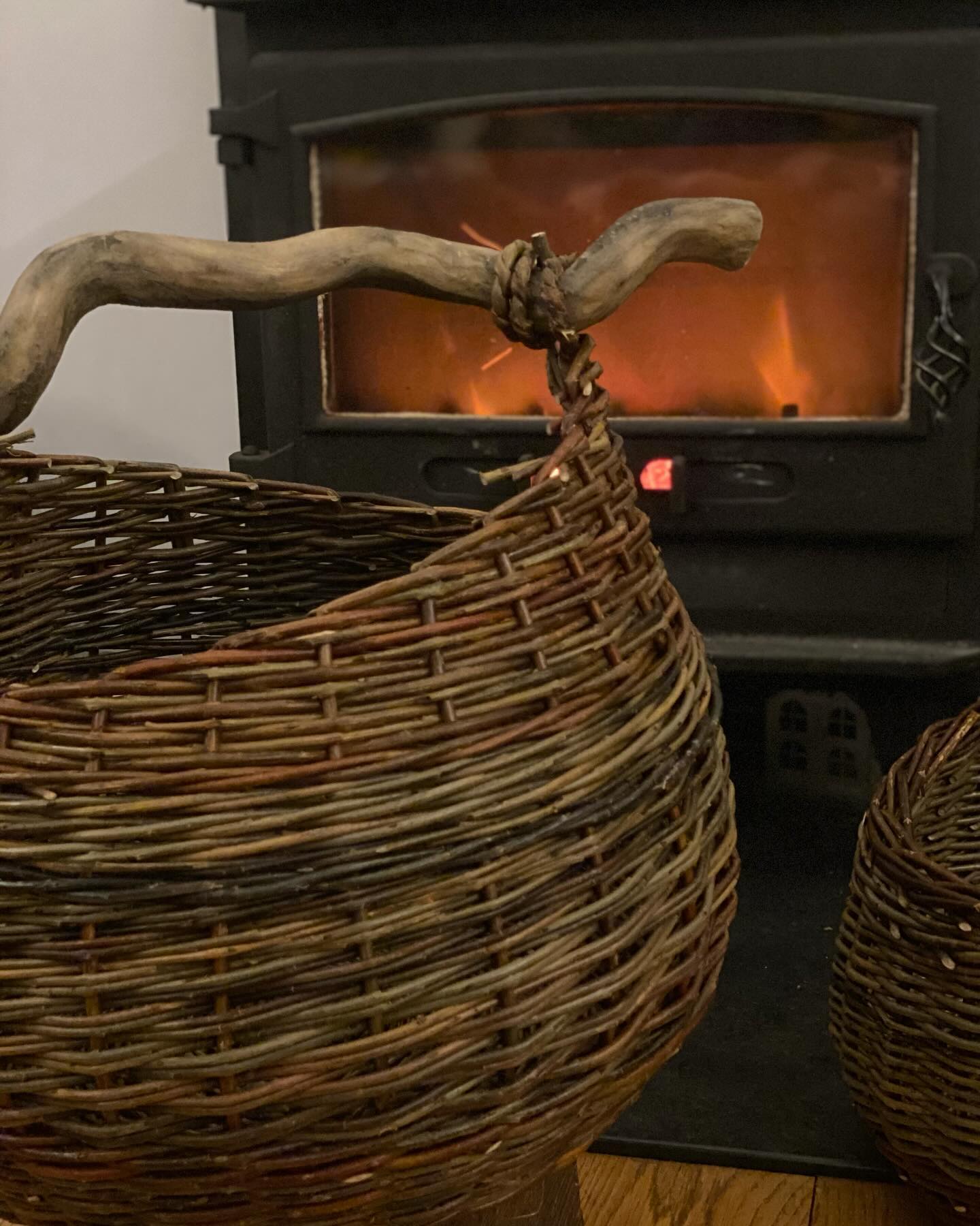 Drying baskets 🔥
-no better excuse to light the fire and cosy up 🤗 !
The handle on this basket was a bit if fun, I really wanted a wiggly handle for it, and I had a bit of Ivy branch nice and dry but the bark was rough and not at all nice in the hand. I decided to take the bark off with my knife but then the wood was too white for the basket 🤔.
Thoughts turned my ebonizing brew which has been on the go for a few weeks now. I’ve not yet had the time I’d like to play with this mix of rusty nails and vinegar, so I went in gentle with just one dainty coat but it worked just enough to let the handle match the basket 😊
I am looking forward to playing with this ebonizing technique more over different types of wood. What I know so far is the mix reacts with tannin in the wood, darkening it. I have a lot of poplar tree in my garden which is low in tannin and so doesn’t react much but a helpful conversation with @alex.finberg 🙏🏻 and a little sachet of powdered tannin later means I can play with a wider variety of woods. 🙂🌱