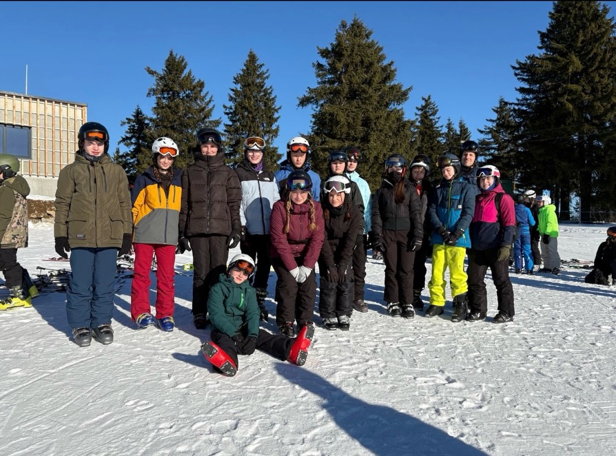 Skilager Alpin der Jahrgangsstufe 7 im Bayrischen Wald 🎿🏔️
In der vergangenen Woche fand das Skilager der Jahrgangsstufe 7 im verschneiten Bayerischen Wald statt. Bei besten Pisten- und Wetterbedingungen und durchweg guter Stimmung verbrachten die Schülerinnen und Schüler erlebnisreiche Tage auf und neben der Skipiste. ⛷️
Je nach Vorerfahrung wurde in Gruppen intensiv geübt. Besonders beeindruckend waren die Fortschritte der Anfänger: Einige von ihnen standen zu Beginn des Skilagers noch nie auf Skiern. Umso größer war der Erfolg, als am Ende der Woche alle Anfänger nicht nur den Schlepp- und Sessellift sicher meisterten, sondern sogar gemeinsam die rote Piste bewältigten. Doch auch die Fortgeschrittenen zeigten großen Einsatz – unabhängig vom Leistungsstand gab jeder sein Bestes und kann stolz auf sich sein! 💪
Selbst von zerbrochenen Skistöcken ließ sich niemand aufhalten. 😁
Trotz zum Teil kurzen Nächten standen alle Schülerinnen und Schüler jeden Morgen motiviert und voller Tatendrang wieder an der Piste und verbrachten gemeinsam mit motivierten Skilehrerinnen und Skilehrern den ganzen Tag im Freien. ❄️🌨️
Natürlich kam auch die Freizeit nicht zu kurz. Diese verbrachten die Jugendlichen gemeinsam in der Jugendherberge – bei Spieleabenden, Auswertungen in den Skigruppen und einem feierlichen Abschlussabend mit traditioneller Skitaufe und besonderen Spitznamen. Große Beliebtheit erfreute sich dabei auch der Snackautomat, der in den freien Momenten rege genutzt wurde. 🍫
Viele gemeisterte Höhenmeter, wenig Schlaf und umso mehr gute Laune bei der Ausübung eines neuen Hobbys sorgten dafür, dass nicht nur perfekte Schwünge im Schnee, sondern vor allem zahlreiche besondere Momente, gemeinsame Erlebnisse und Erfahrungen im Gedächtnis bleiben werden – und noch lange Gesprächsthema sein werden. 🩵❄️
Lio Wunderlich & Adrian Heerwagen, 7a
#skilager #graupnergym
