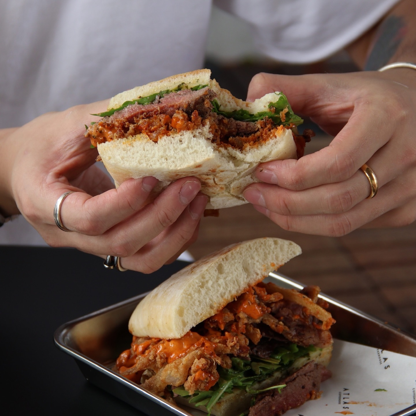 All you need is to take a bite.
Steak Sandwich — Sliced steak stacked between rocket, crispy onions, salsa verde, red pepper smokey sauce, Emmental cheese, ciabatta.