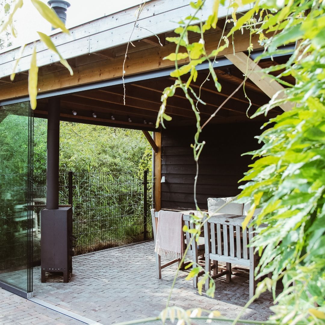 Dé overkapping
Door de steeds langere zomers en kortere winters veranderd de wens van de leefomgeving in de tuin. In warme landen zie je al vaak een veranda aan huis gebouwd. Wij nederlanders kiezen vaak toch voor een aparte overkapping zodat je het zonlicht in de herfst in winter binnen houdt.
Deze extra plek zorgt dat je in zomer even lekker uit de zon kan zitten en eten. En dat op de iets koelere avonden toch een fijne plek hebt om gezellig te zitten. Ook kiezen steeds meer gezinnen ervoor om een overkapping te creëren zodat de jeugd een eigen plekje heeft.
Als ik soms door mijn eigen woonwijk kijk zie ik soms tuinen vol gebouwd of is de vormgeving van zo’n overkapping echt tenenkrommend. Daarom neem ik het onderdeel overkapping altijd mee in het tuinplan als het de wens van de klant is. De overkapping werk ik dan uit tot 3D ontwerp of ik maak stylingplan van zo’n ruimte.